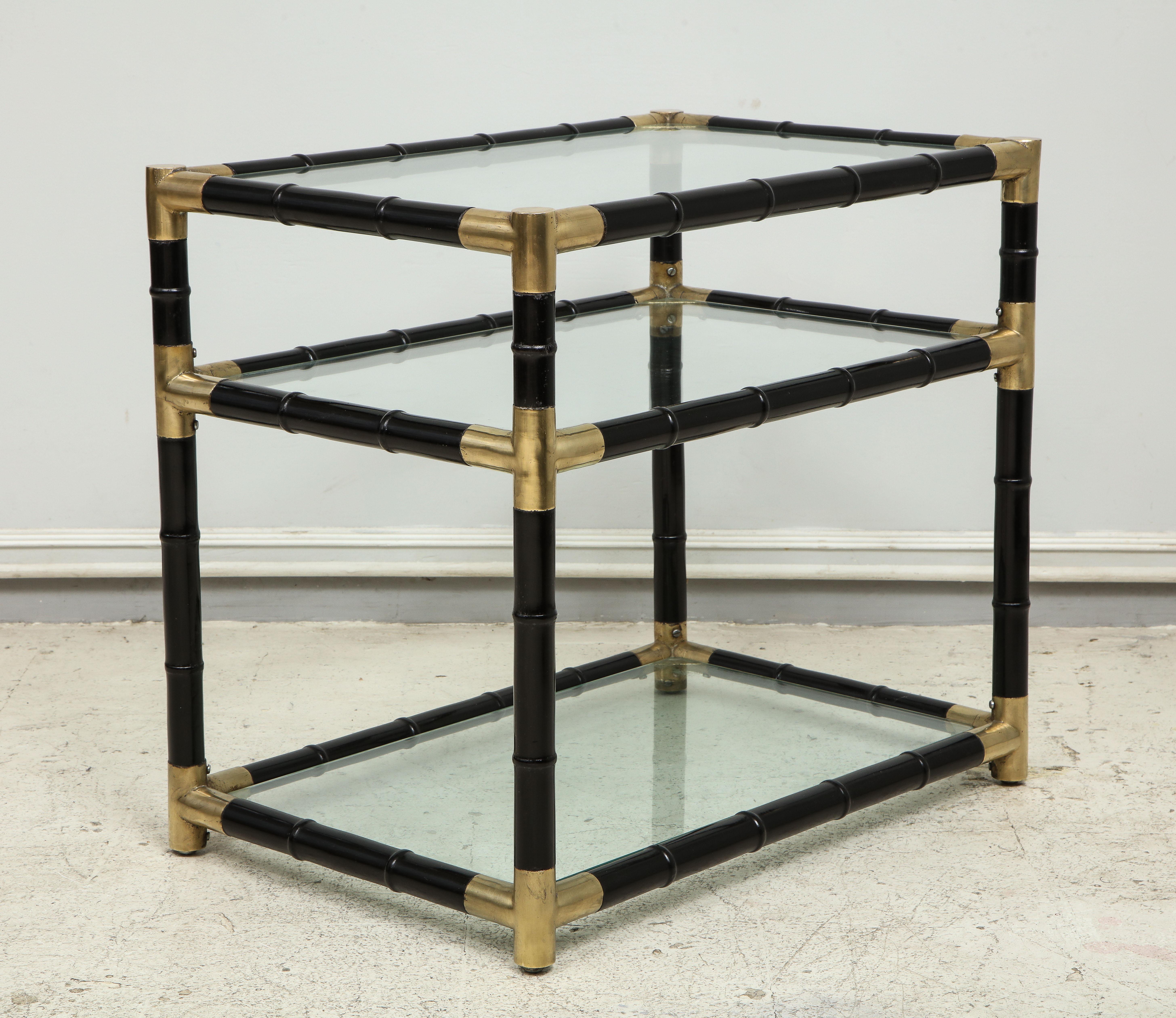 Pair of midcentury ebonized faux-bamboo and brass three-tiered tables.