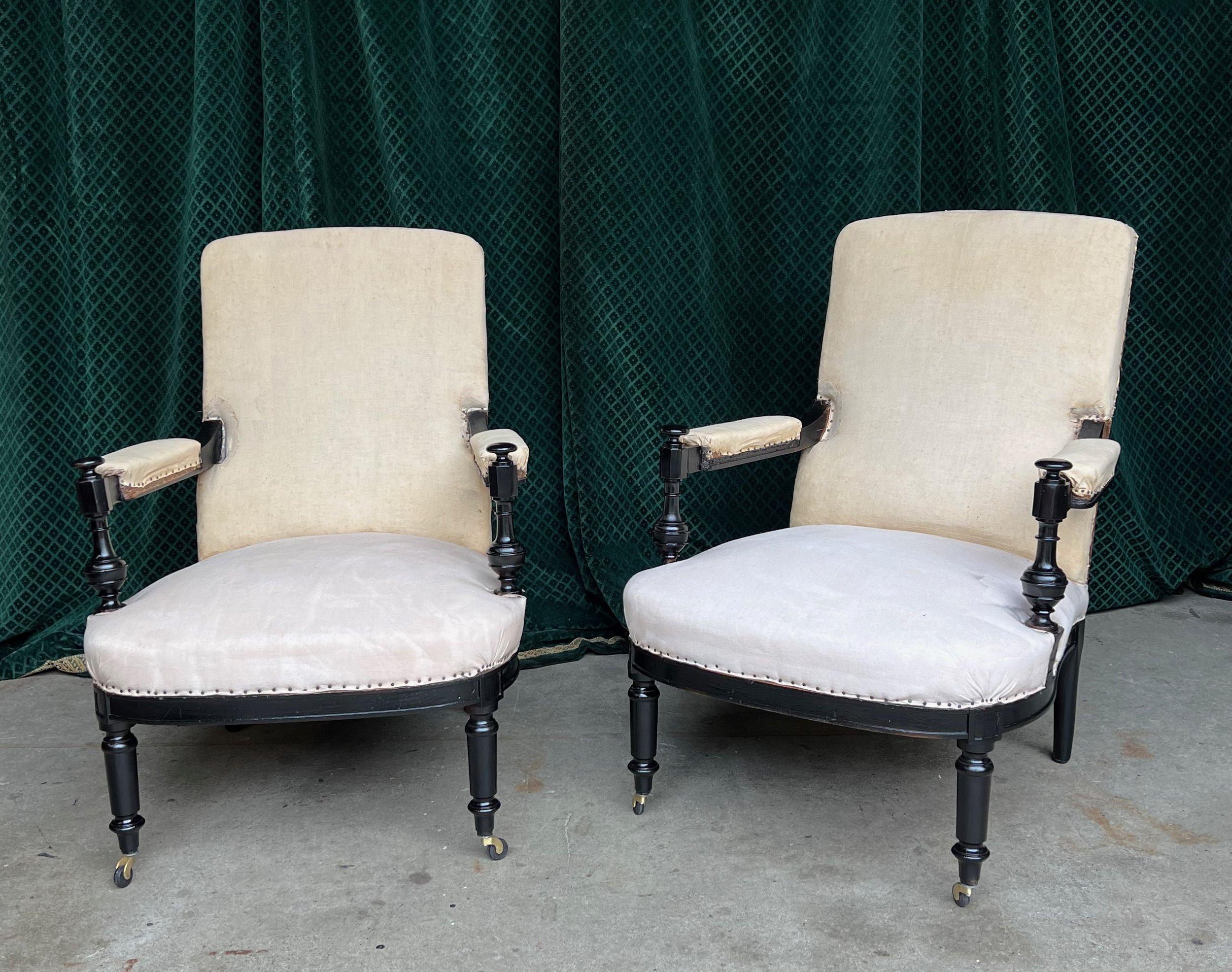 A classic pair of French Napoleon III armchairs, distinguished by their visible wooden arms and iconic turned legs. Originating from the 19th century, these chairs are captivating with their stunning spindle arm details, bringing a touch of