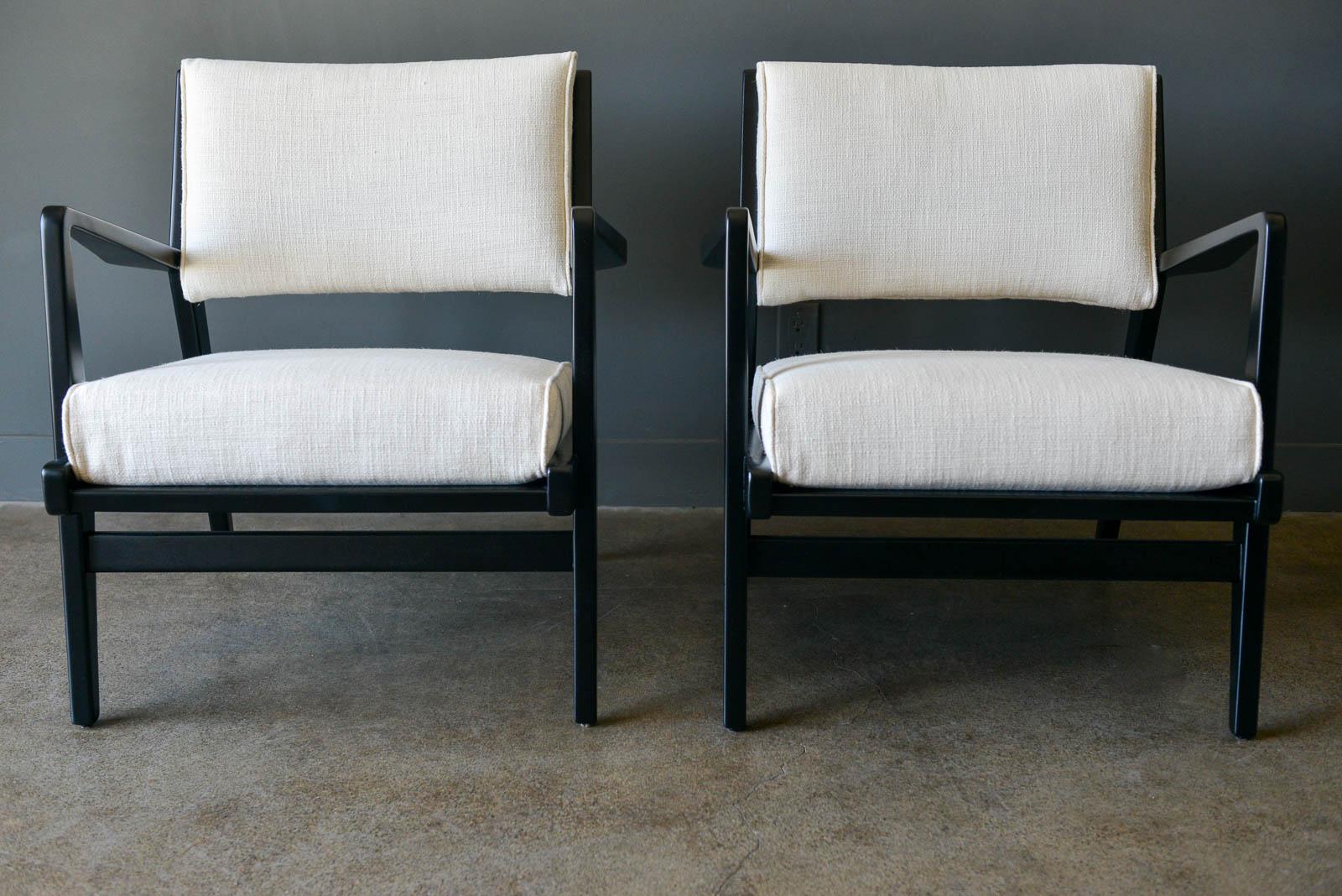 Pair of ebonized lounge chairs by Jens Risom, ca. 1965. Newly refinished and reupholstered in beautiful easy care oyster colored tweed, these Classic chairs are very comfortable with solid wood seats under the cushions and sloping sculpted arms.