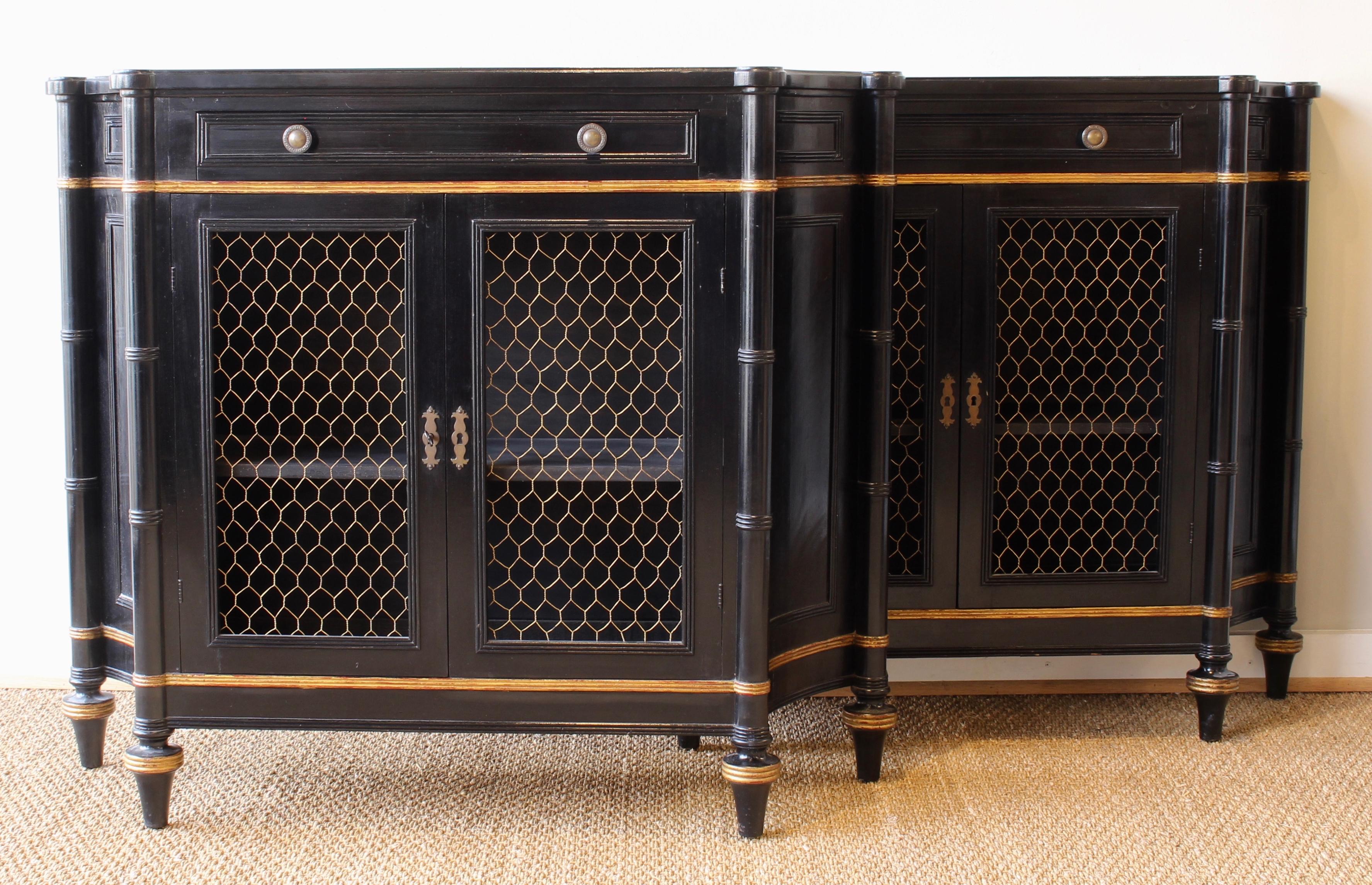 A charming pair of mid-20th century ebonized Regency style credenzas each with a single drawer above double cabinet doors inset with brass grillwork