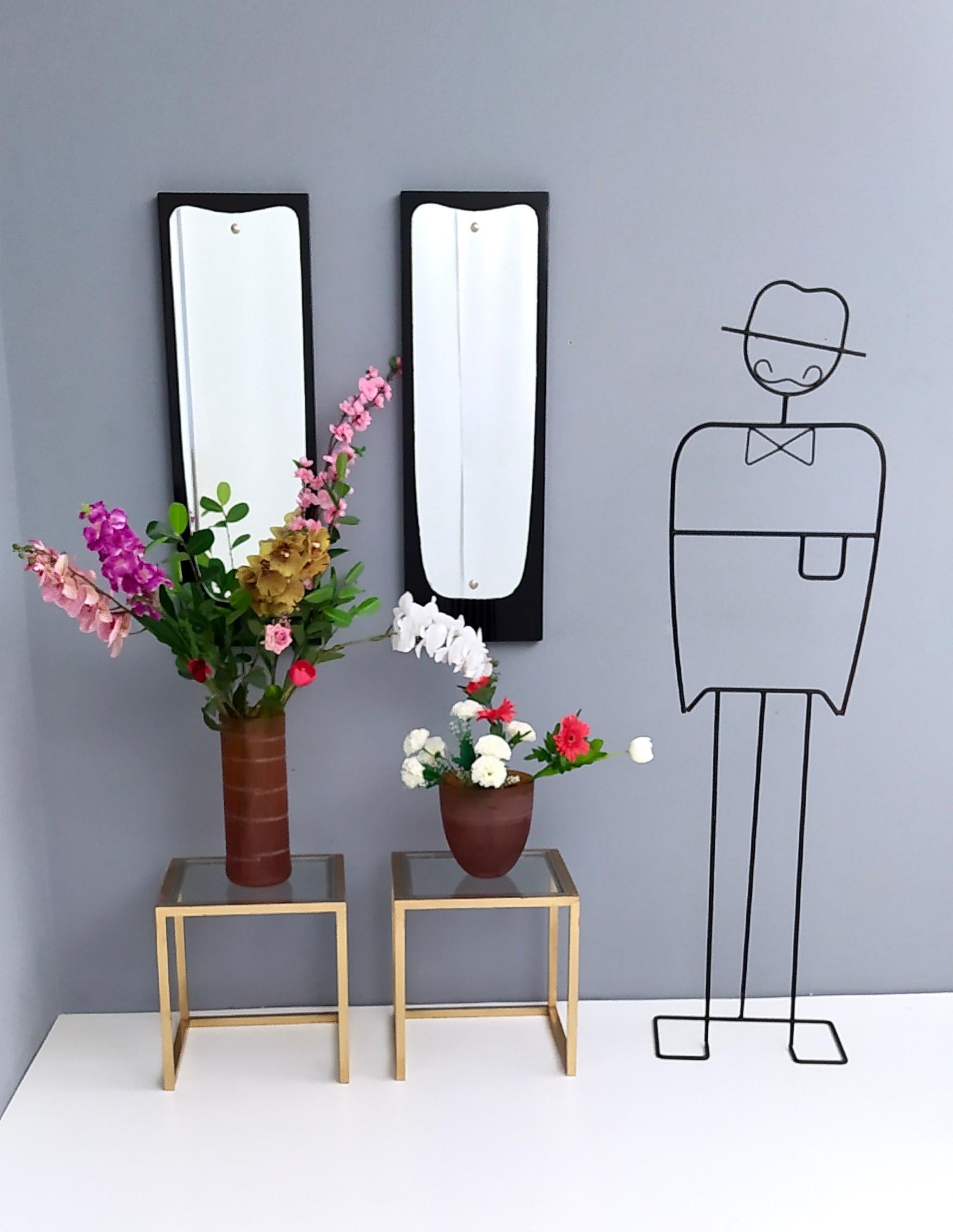 Made in Italy, 1950s.
They are made in ebonized wood and feature nickel-plated brass details. 
One of them has a slight sign of oxidation due to time. 
These mirrors are vintage, therefore they might show slight traces of use, but they can be