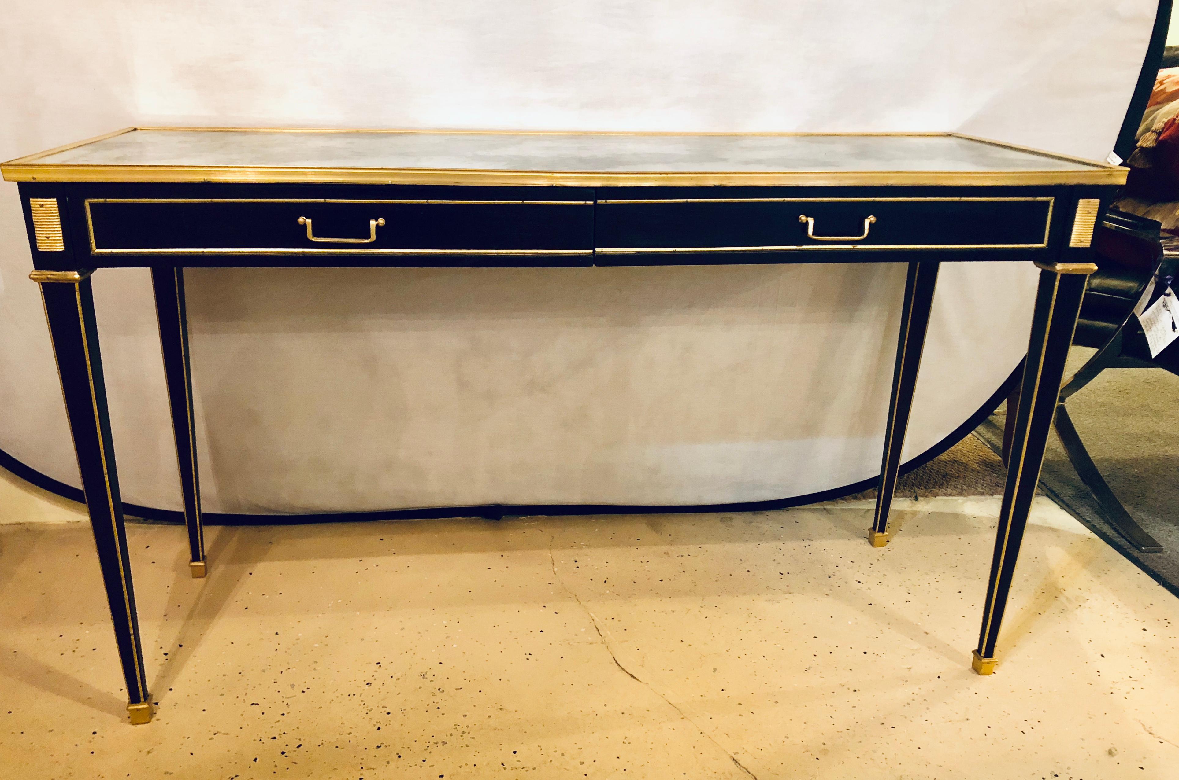 Pair of Ebony Maison Jansen Style Mirror Top 2 Drawer Console with Bronze Mounts. Each having tapering legs with bronze mounts and cookie cutter corners. Each with an antiqued mirror top.