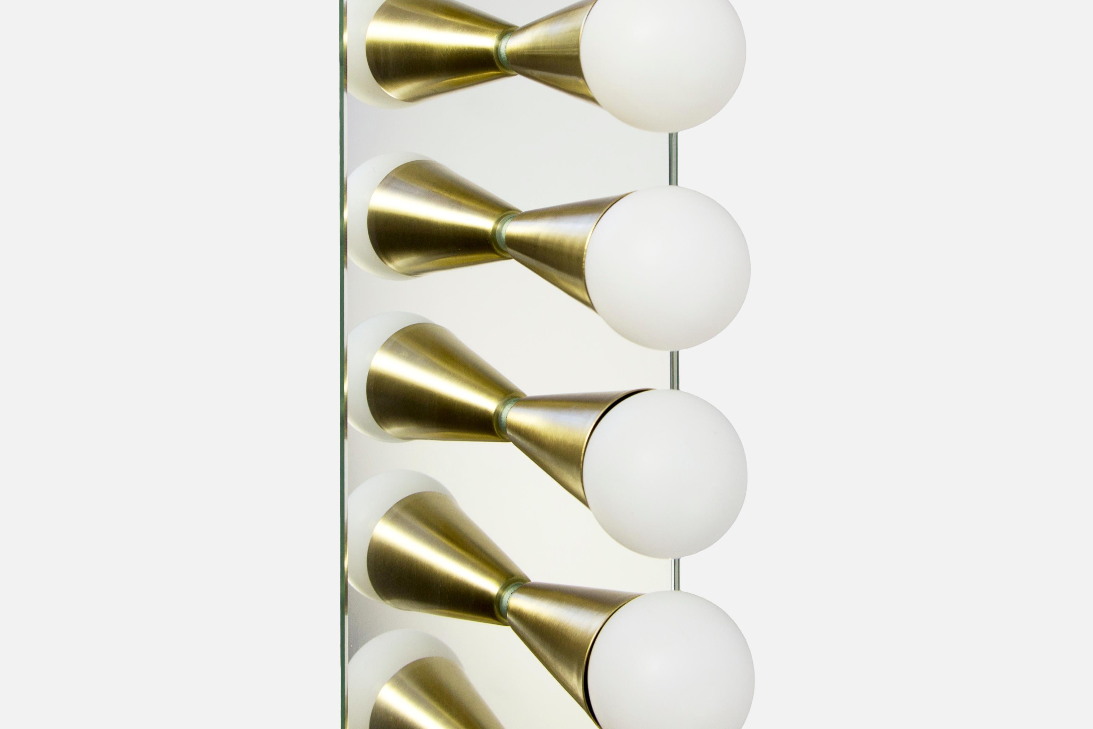 Simple, elegant and playful, the Echo series is a line of surface mount fixtures that can be used on a wall or ceiling. White or brass cones mount to mirrored glass to perfectly reflect each bulb, giving the illusion of lights floating in space.