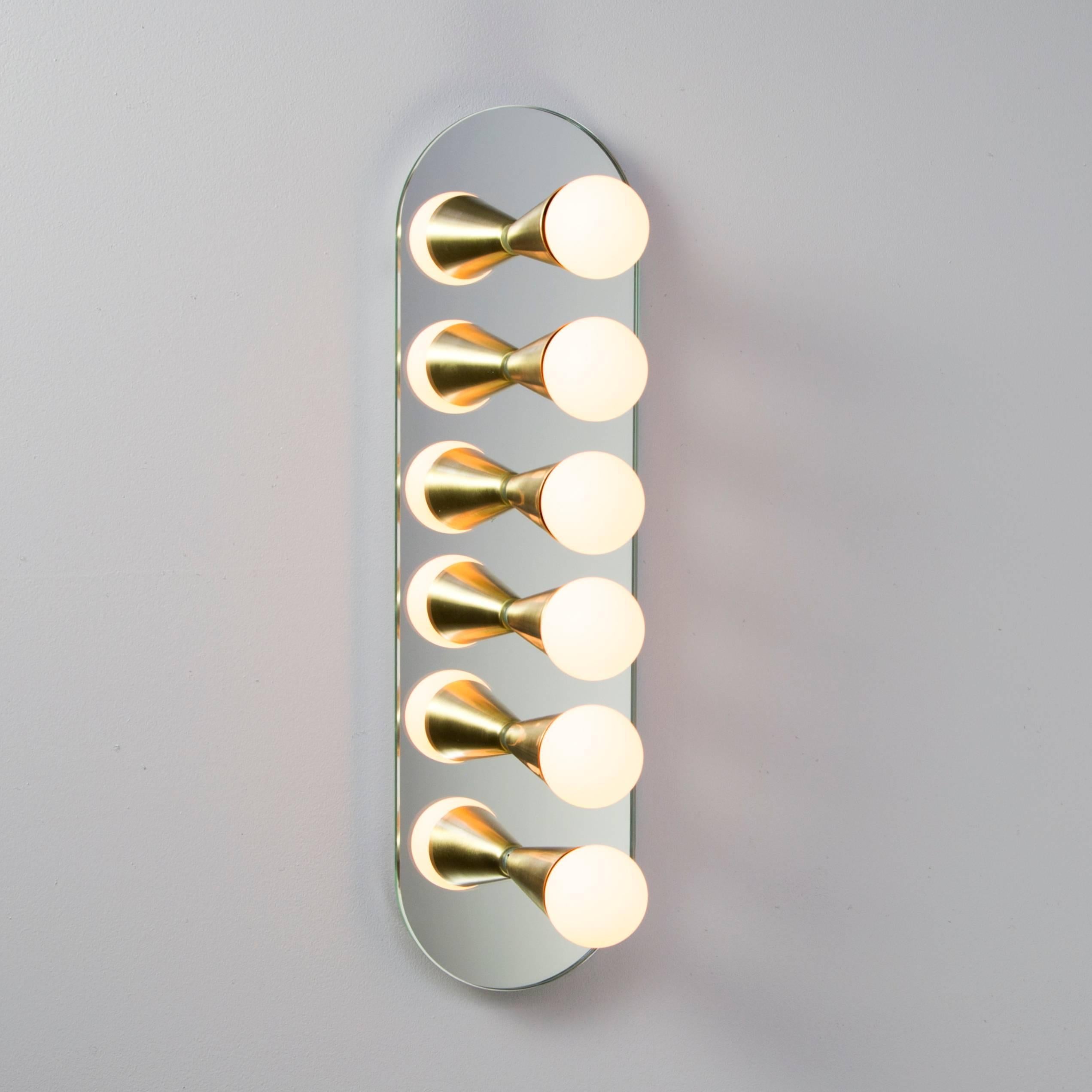 Simple, elegant and playful, the Echo Series is a line of surface-mount fixtures that can be used on a wall or ceiling. White or brass cones mount to mirrored glass to perfectly reflect each bulb, giving the illusion of lights floating in