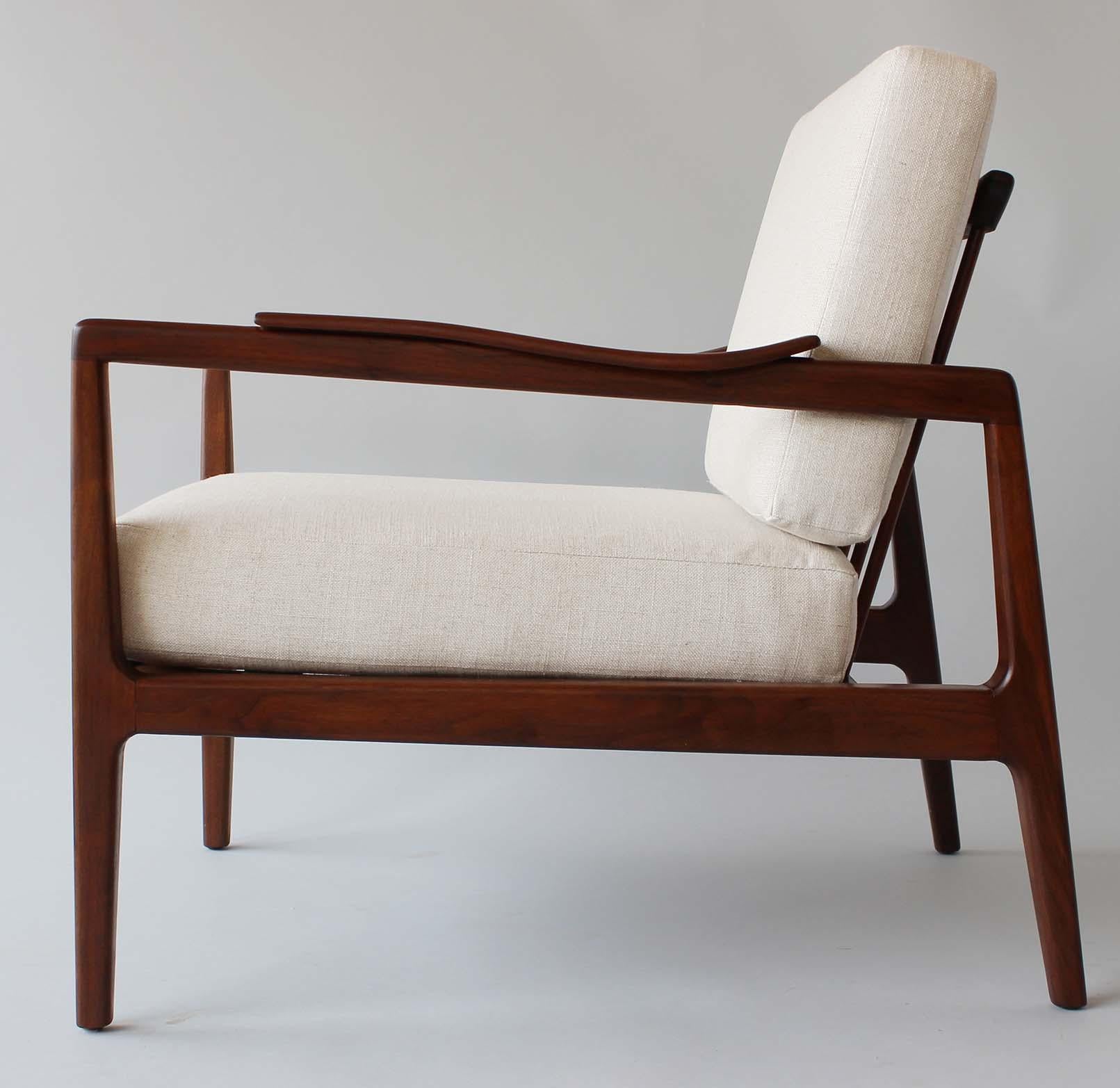 A pair of walnut frame armchairs with new cushions, designed by Edmond Spence for Modernage.

