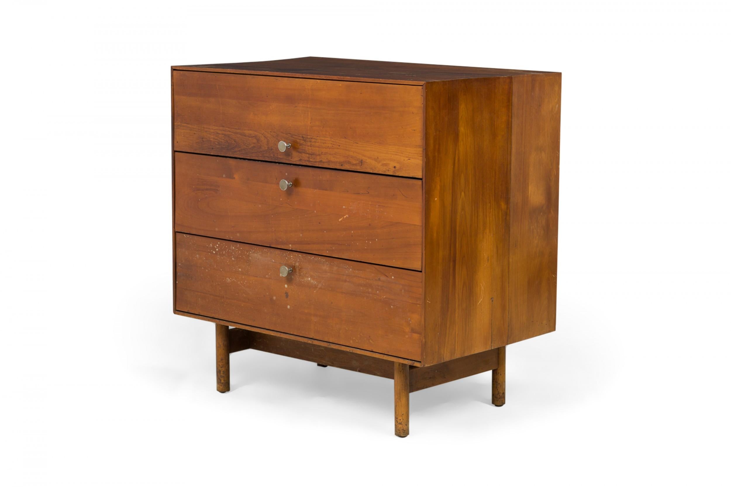 PAIR of American Mid-Century 3-drawer rectangular walnut chests with circular brushed chrome drawer pulls, resting on four dowel legs. (EDMOND SPENCE FOR WHITNEY FURNITURE CO.)(PRICED AS PAIR)

