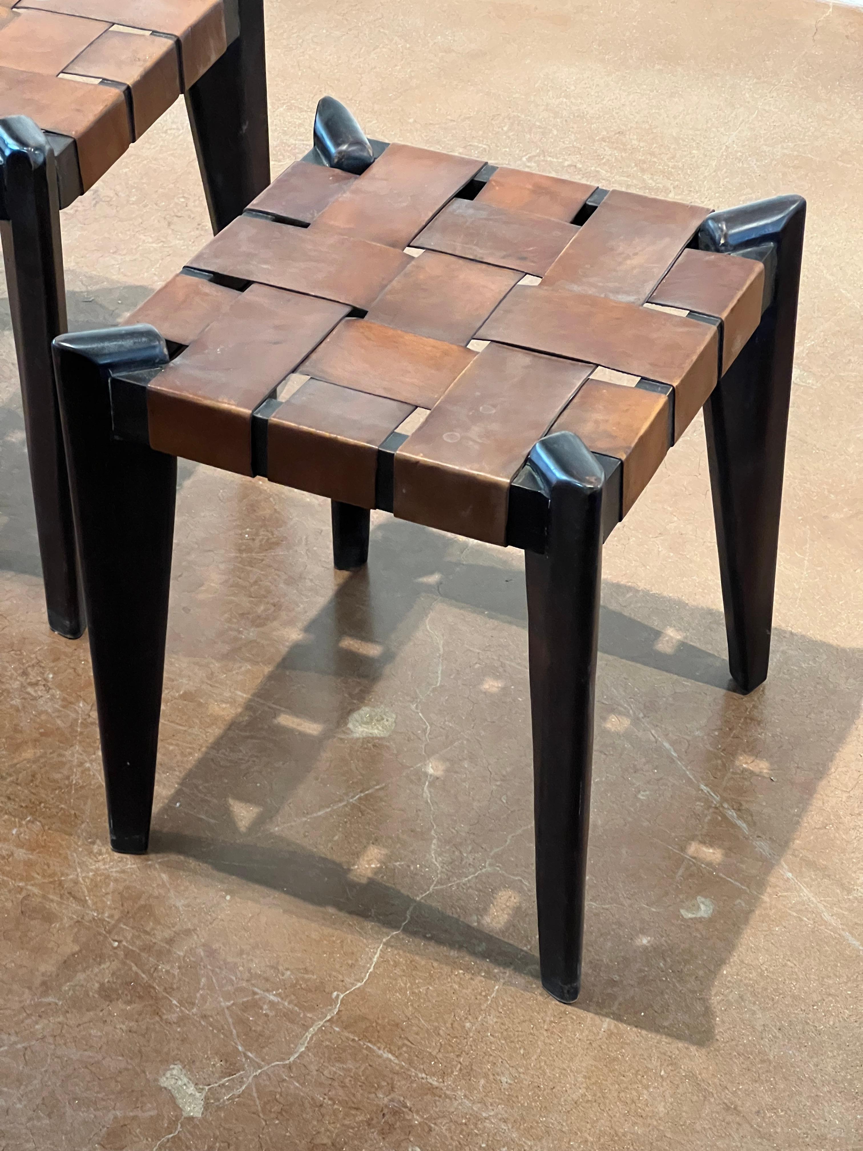 Pair of woven leather and teak wood ottomans by Edmond J. Spence. Original leather and dark stained teak. 