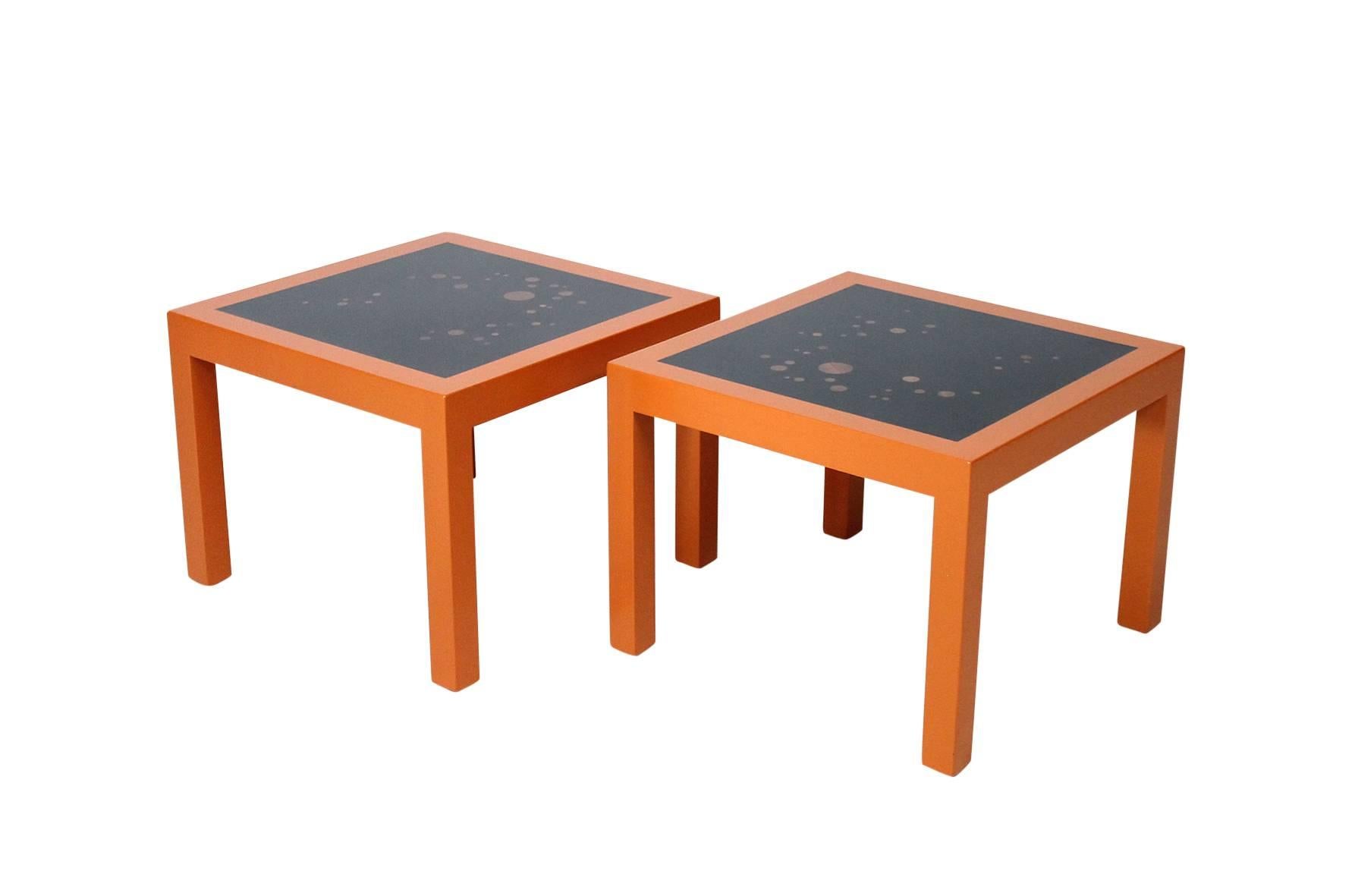 A rare pair of Edward Wormley for Dunbar end tables with orange lacquered frames, black tops, and an array of walnut inlays. Signed with metal Dunbar label.