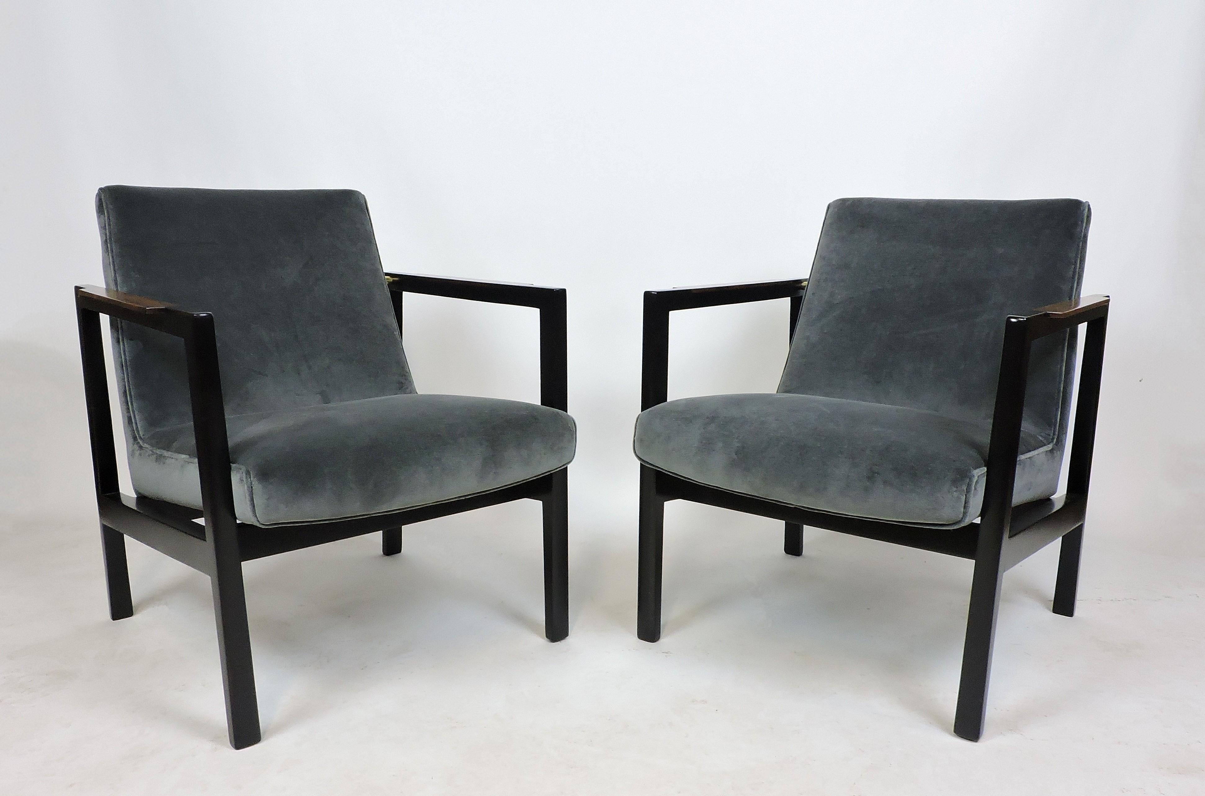 Elegant and sophisticated pair of open arm lounge chairs designed by Edward Wormley and manufactured by Dunbar. These clean lined chairs are made of mahogany and rosewood with brass accents and are newly reupholstered in a luxurious gray velvet.
