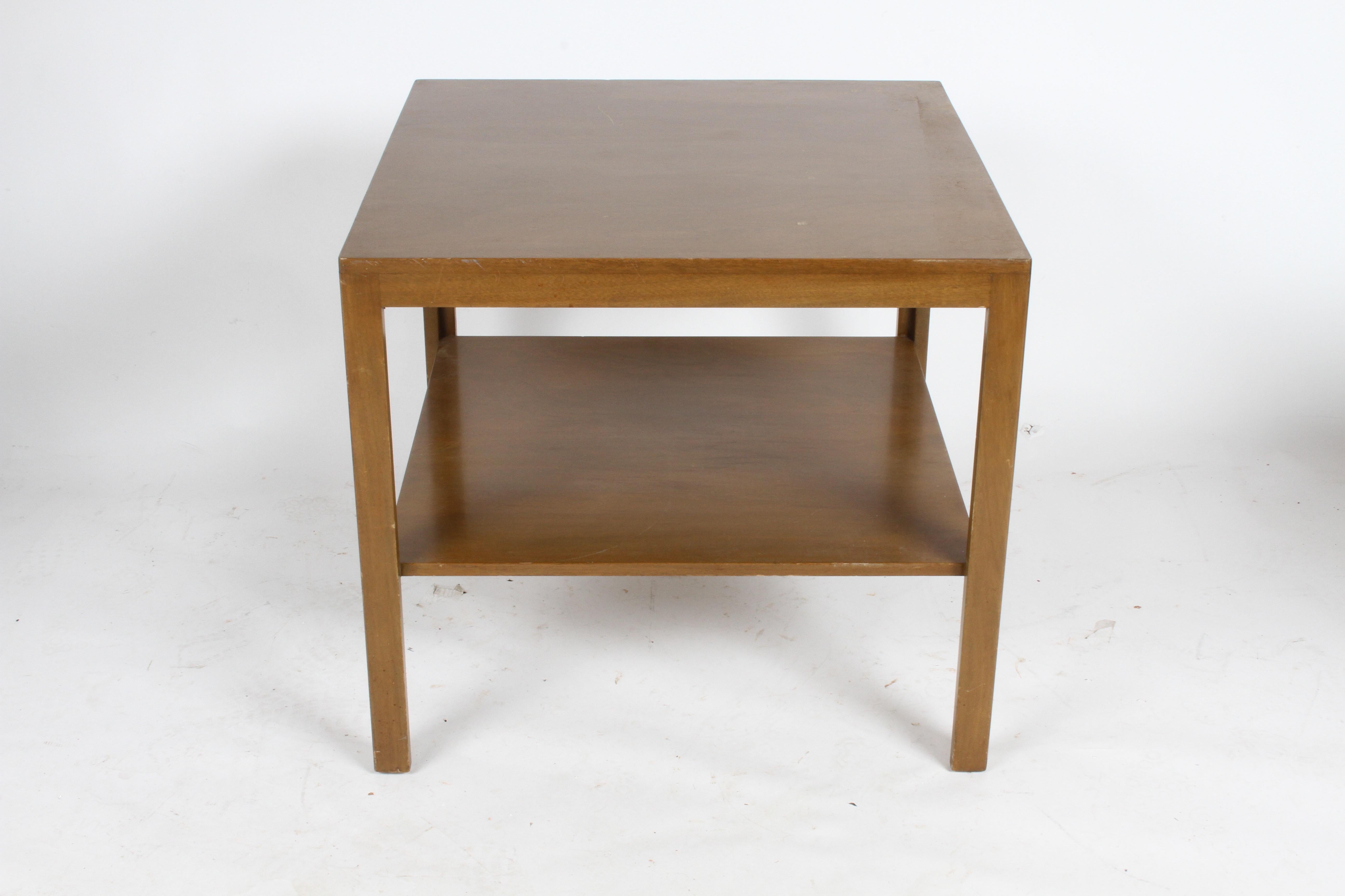 Pair of end tables in walnut, designed by Edward Wormley for Dunbar, early green labels. Currently being refinished (matching two-tiered coffee table also available). The tables show in dark finish are sold, please see others shown in photos, to be