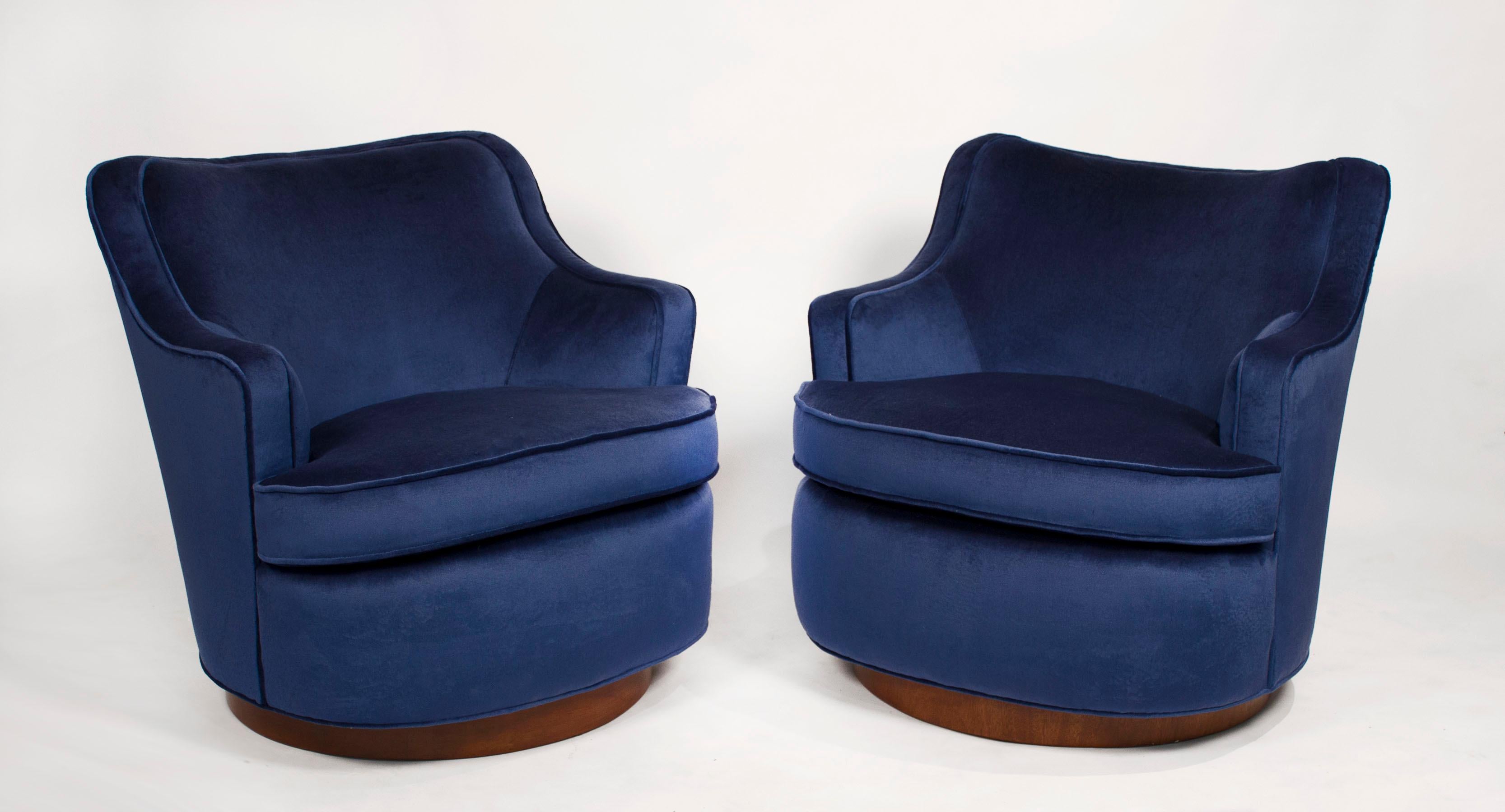 Early pair of Dunbar swivel chairs fully restored in high grade blue velvet. New foam and hand tied springs. These are extremely comfortable even for a tall person and are very high-quality construction with solid hardwood frames.