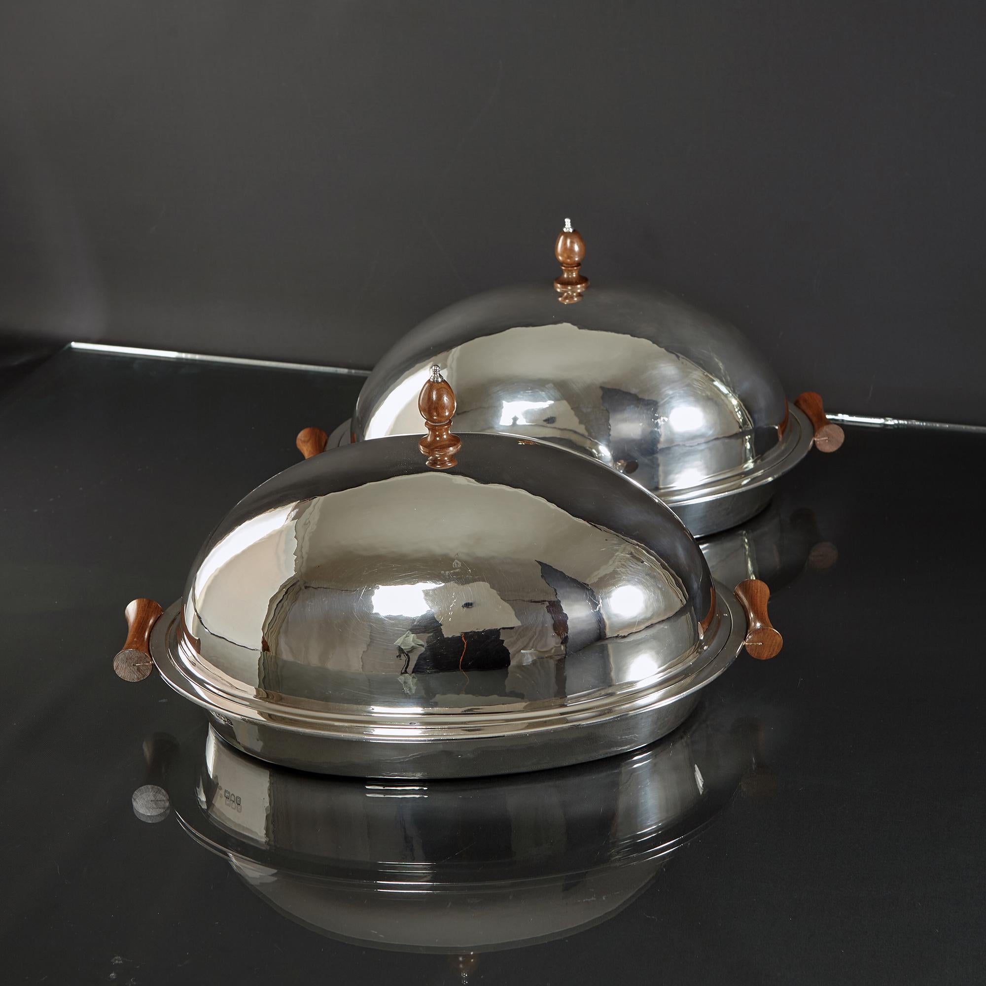 A pair of antique silver game serving dishes and covers. These are quite rare and of a useable size for serving not only game, but also chickens, small roasts and any number of vegetable recipes.

The domed covers and bases are hand raised and the