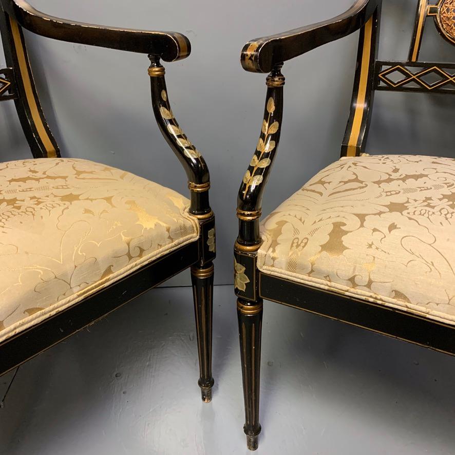 Early 20th Century Pair of Edwardian Black Lacquered and Gilt Highlighted Elbow Chairs with Cane