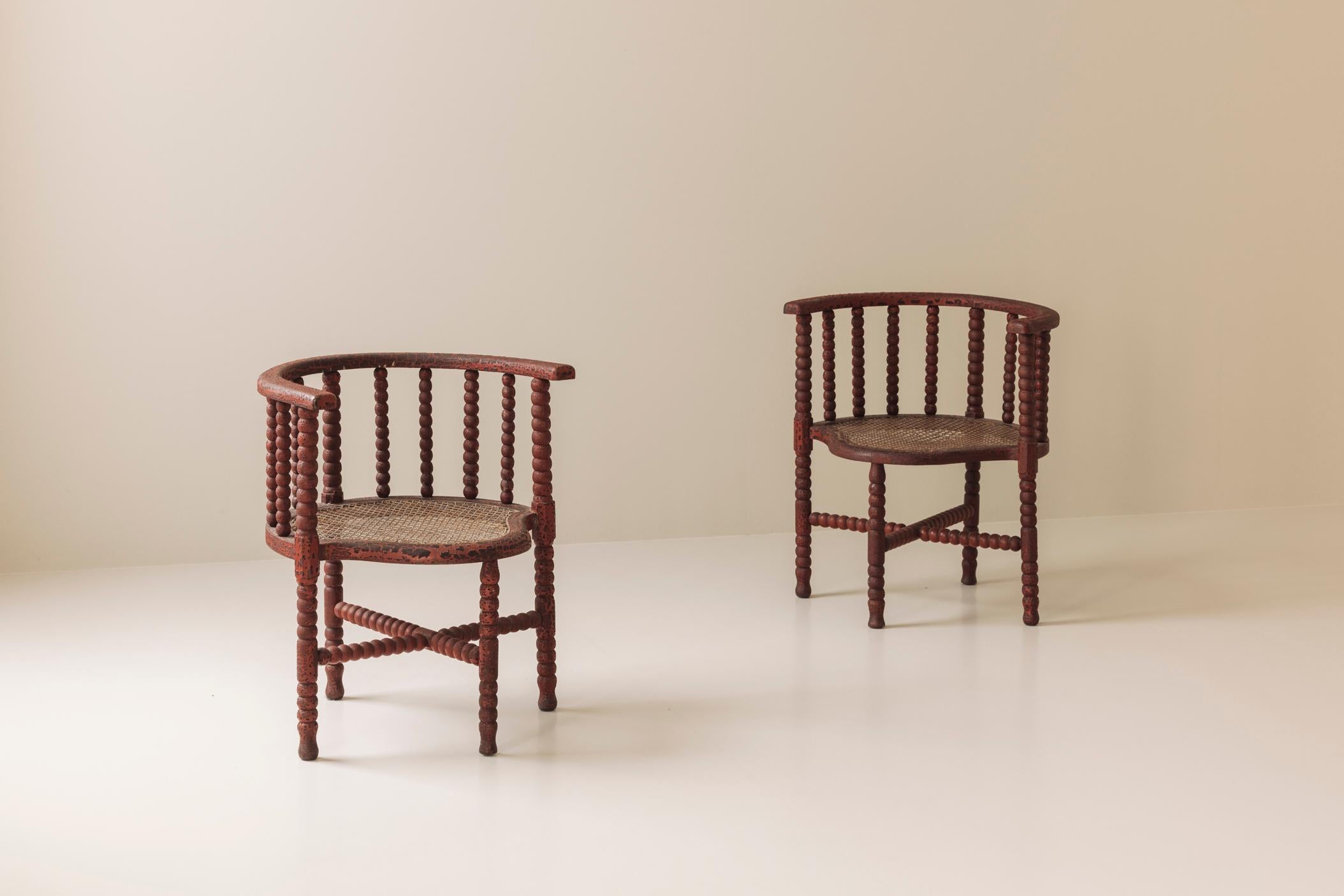 Questa bellissima coppia di poltrone a tombolo edoardiane risale all'inizio del XX secolo e mette in mostra la maestria e il fascino di un'epoca passata. Il loro caratteristico telaio tornito 