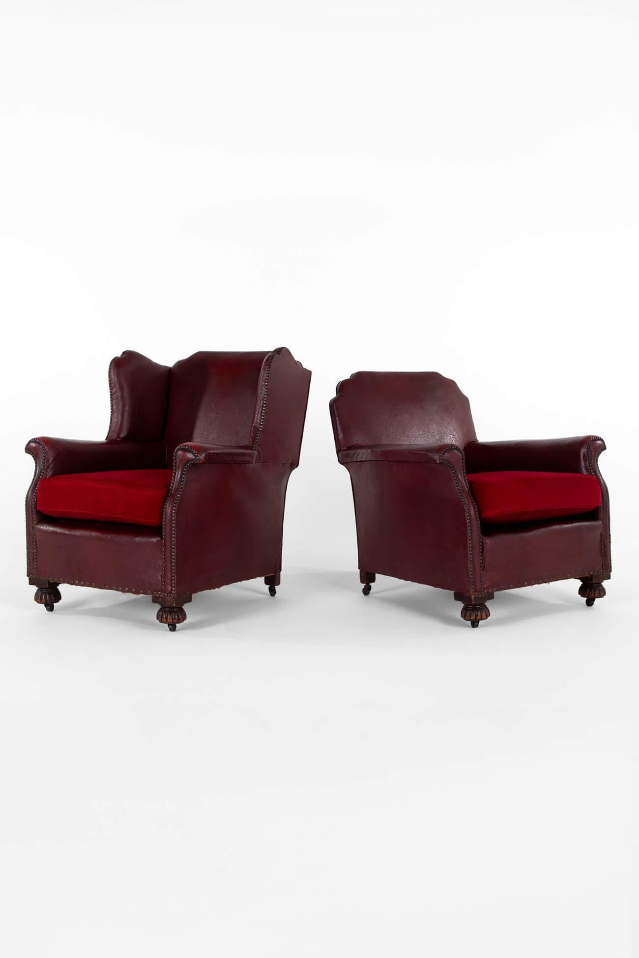 A superb pair of Edwardian fireside chairs in faux burgundy leather with just the right amount of wear to the arms and backs.

The pair are a mix of styles with the ‘male’ having a high wing back and the slightly shorter ‘female’ chair with a square