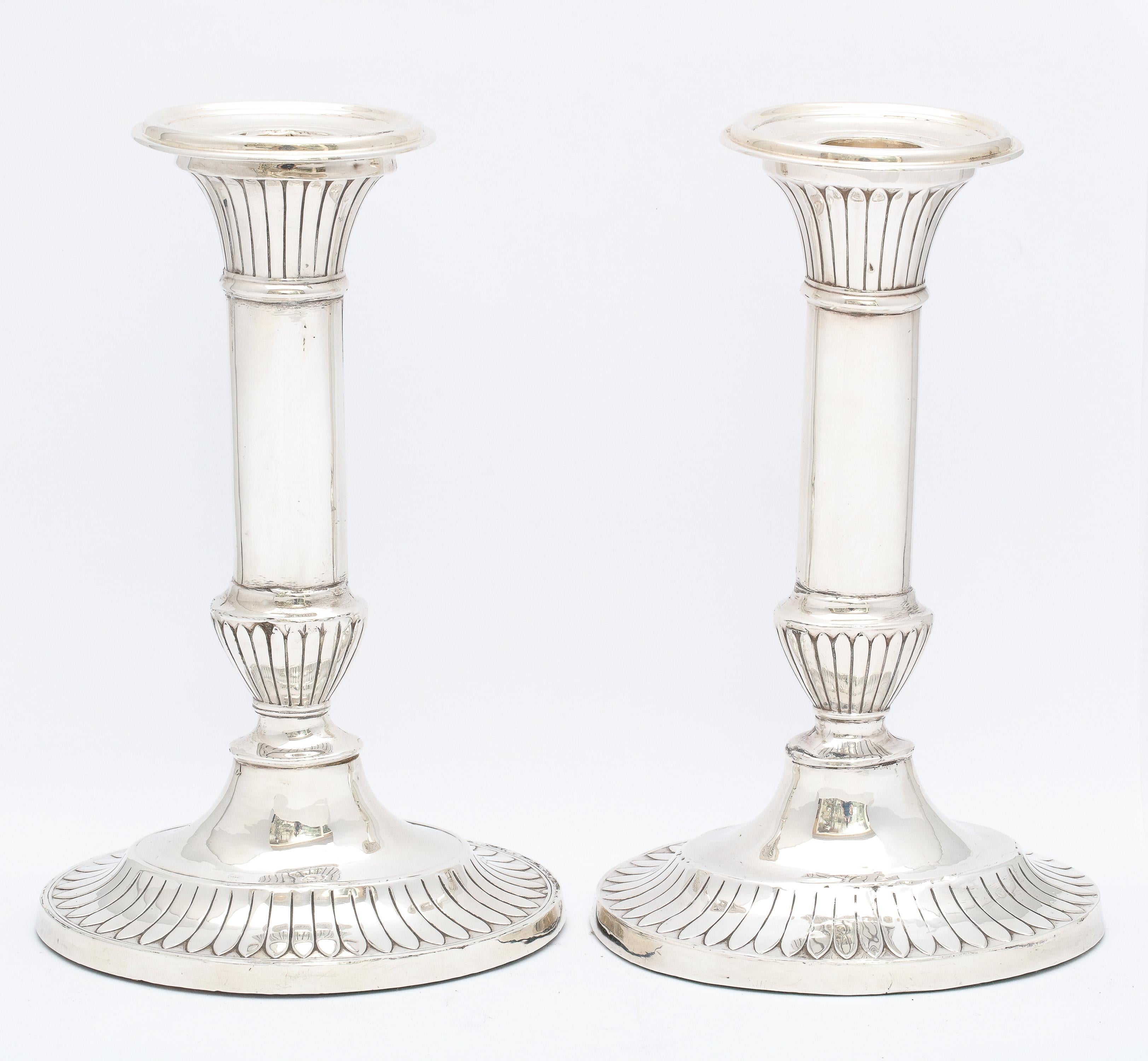 Pair of sterling silver George III-Style candlesticks, made in the Edwardian Period, Birmingham, England, year-hallmarked for 1912, Mappin and Webb - makers. Each candlestick measures 7 1/2 inches high x 4 3/4 inches wide (at widest point) x 3 3/4