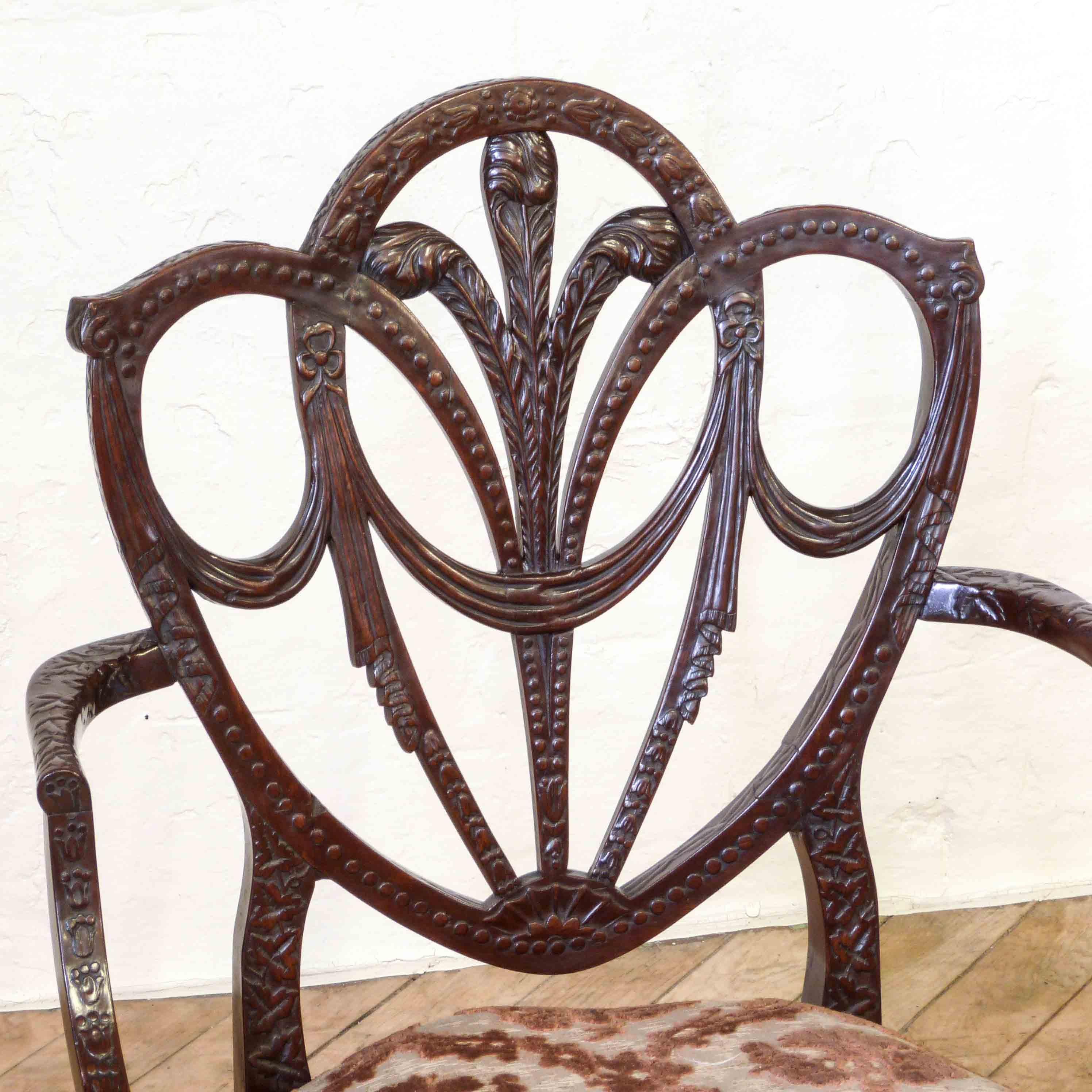 Ein Paar edwardianische Mahagoni-Sessel in der Art von Hepplewhite. Reichlich beschnitzt mit Laub, Blumen, Bändern und Schwänzen. Der zentrale Schildrücken ist mit Prince of Wales-Federn abgesetzt. Der Zustand ist sehr gut, die Polsterung weist