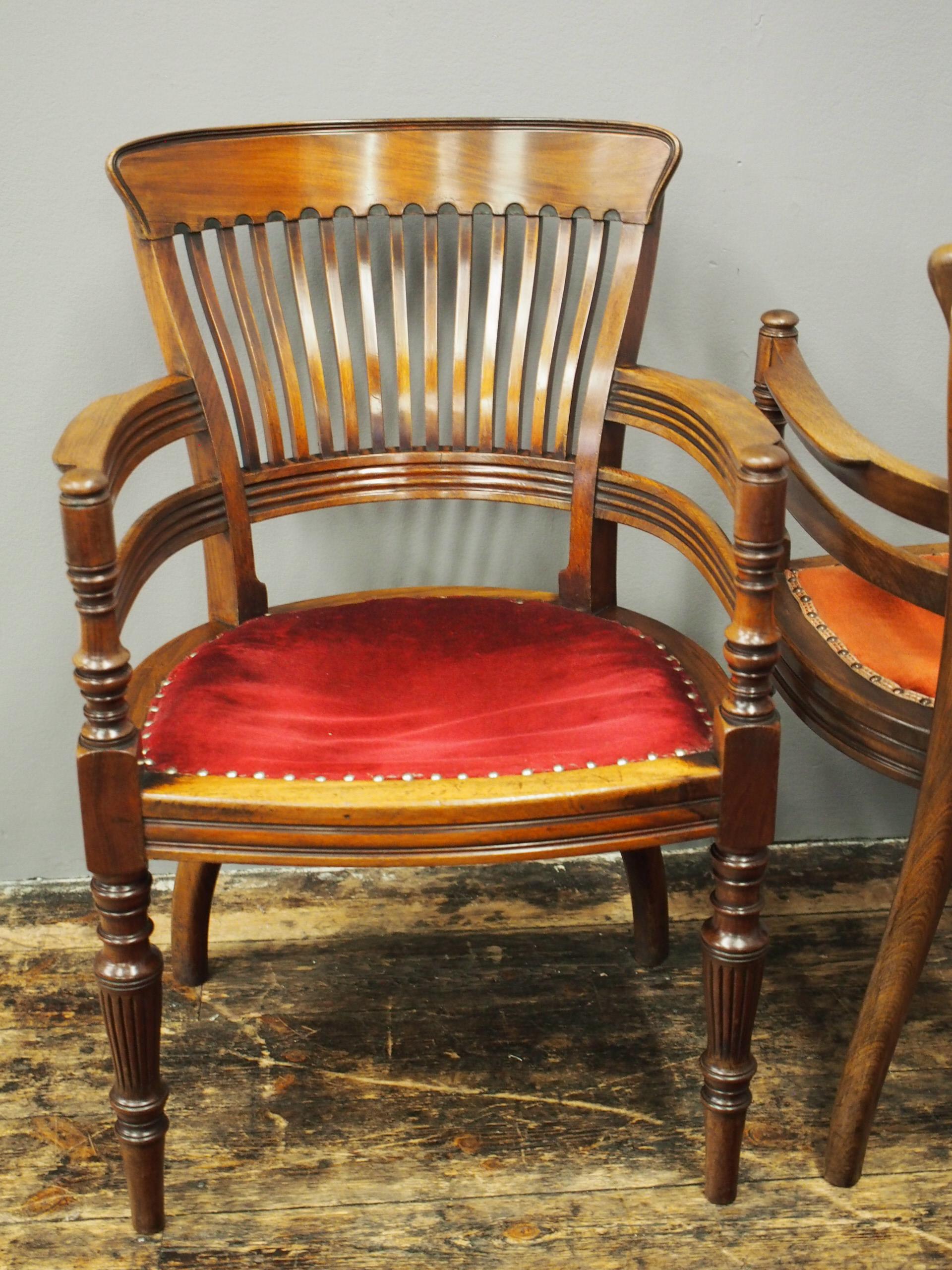 Pair of Edwardian mahogany office chairs, circa 1900. The curved top rail is on shaped splats and supports, and sits above a fluted lower rail that continues on to fluted arms. The turned arm supports extend down to become the turned front feet, and
