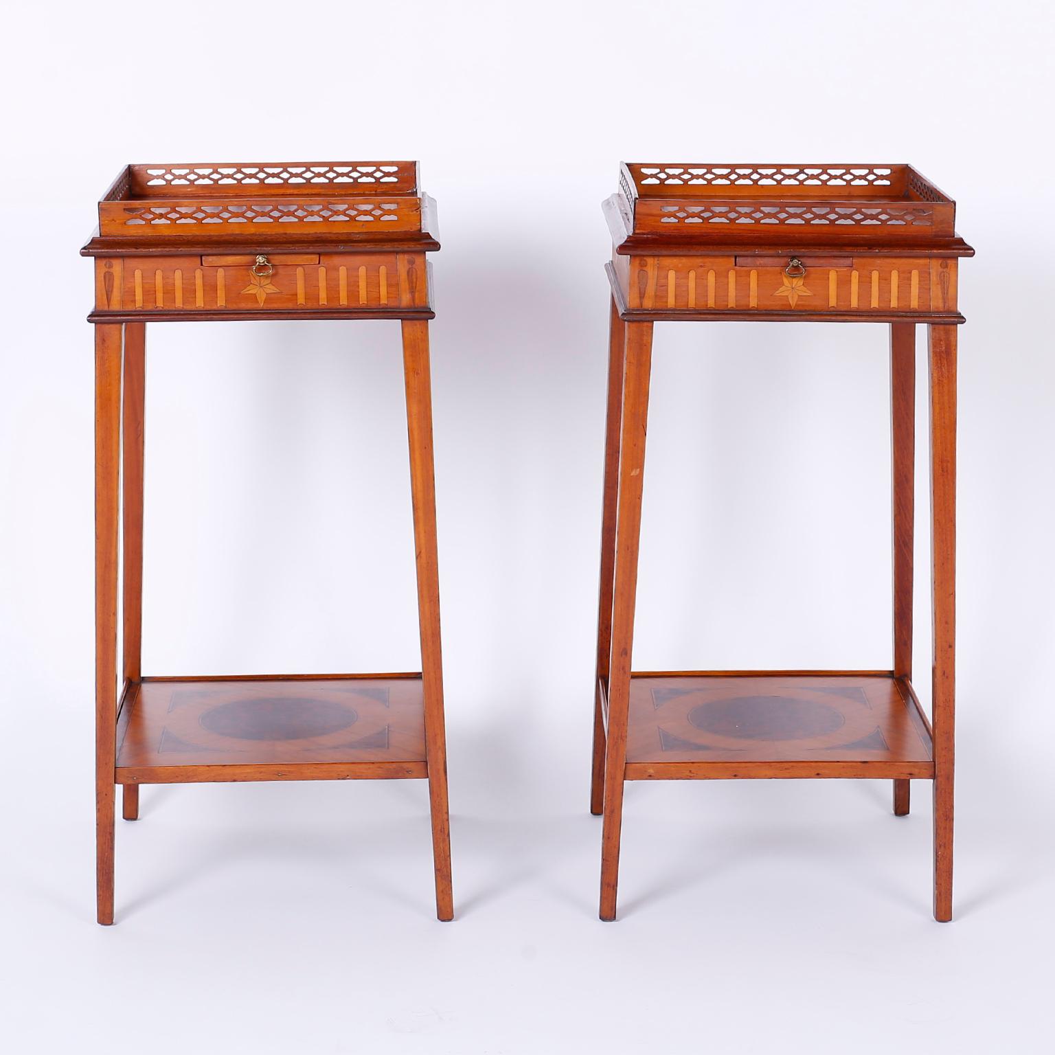 Fine pair of antique Edwardian stands or tables crafted in mahogany with burled walnut and satinwood inlays. Featuring a gallery on top, slide out drinks tray, and a Classic elegant form.