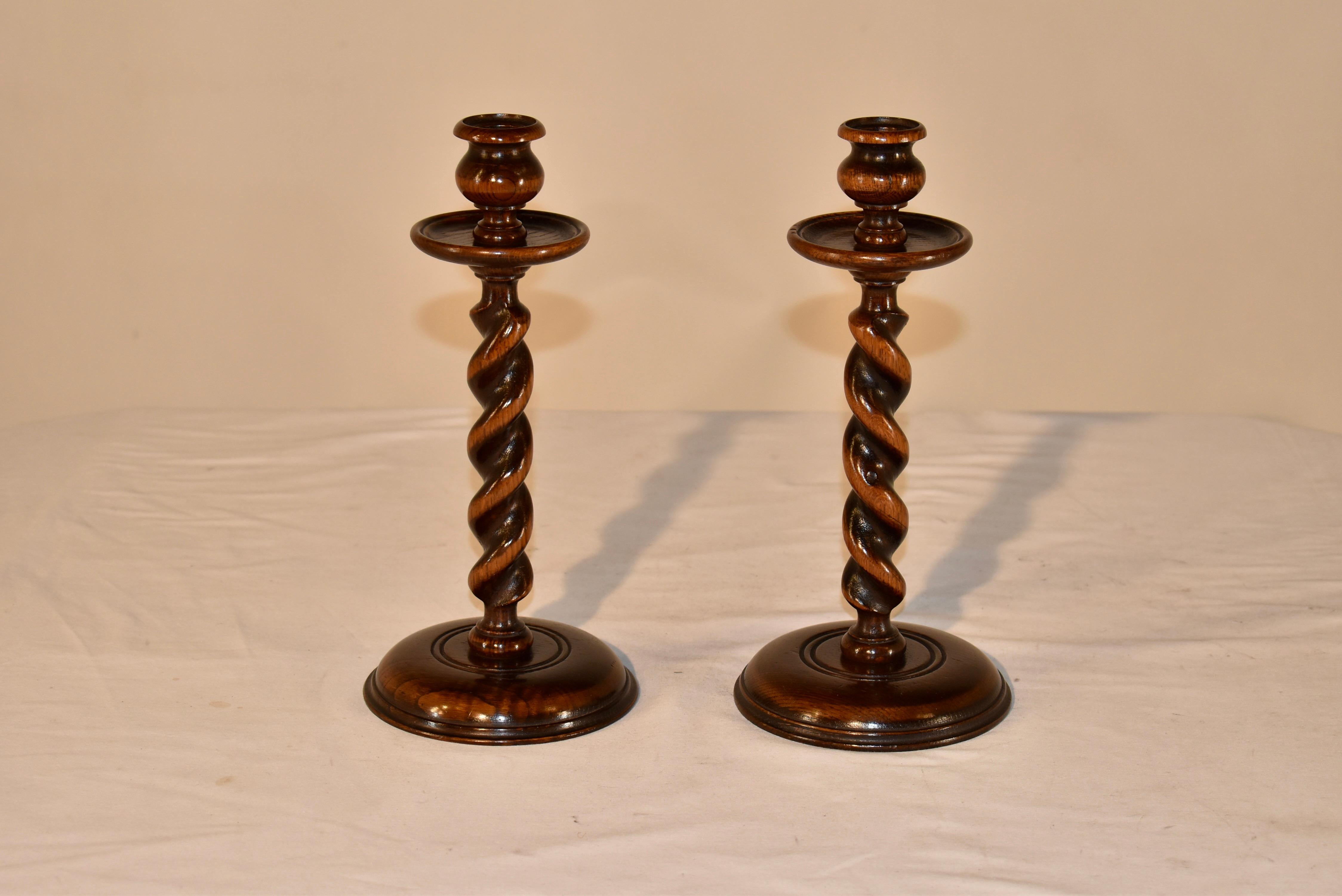 Coppia di candelabri edoardiani in quercia provenienti dall'Inghilterra, circa 1900.  Le coppe per le candele hanno una forma elegante e sono dotate di bobeches sotto di esse per raccogliere i residui delle candele.  Gli steli sono torniti a mano in