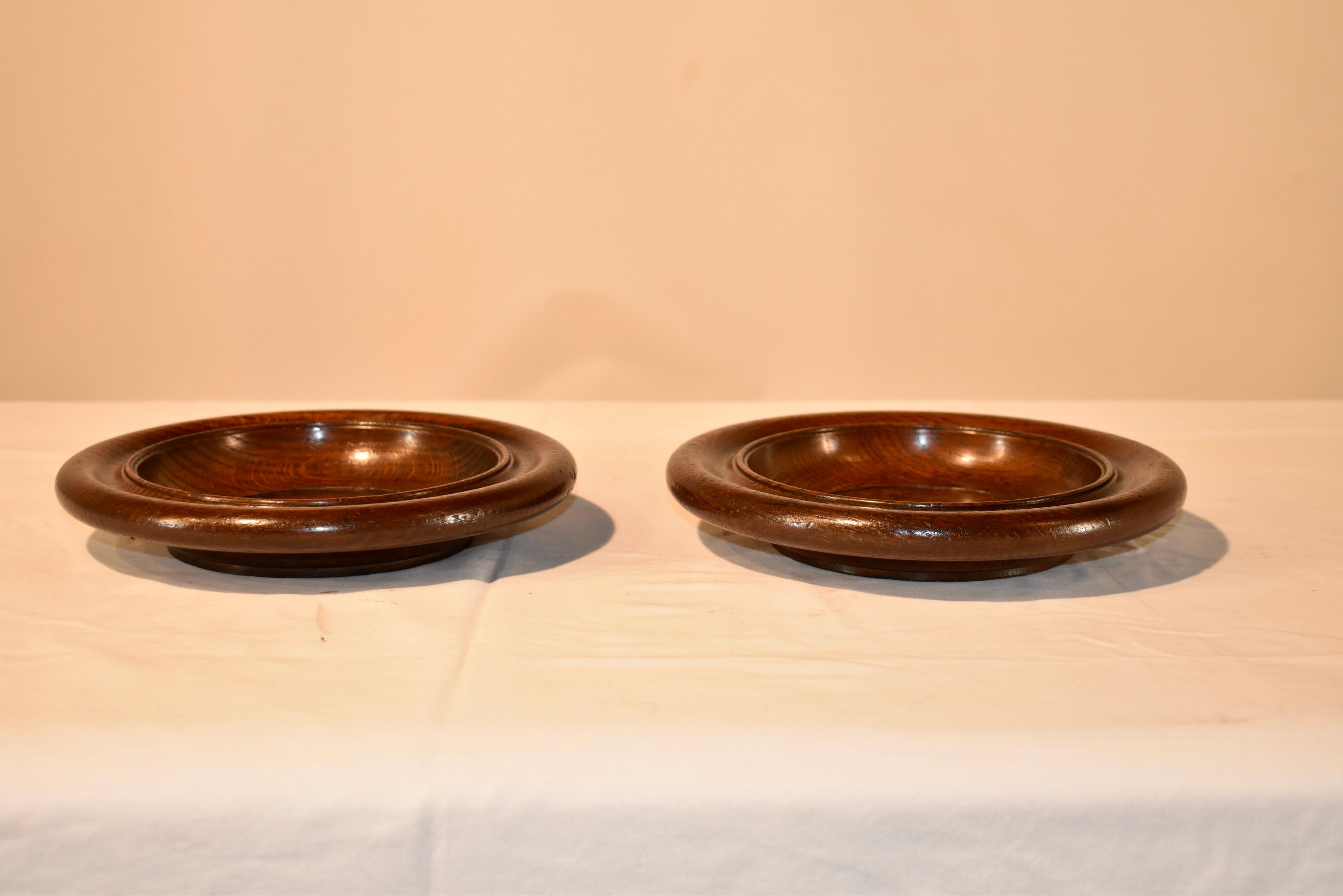 Pair of Edwardian oak turned wine coasters or shallow bowls which are wonderfully hand turned. Lovely accent for many areas in the home.