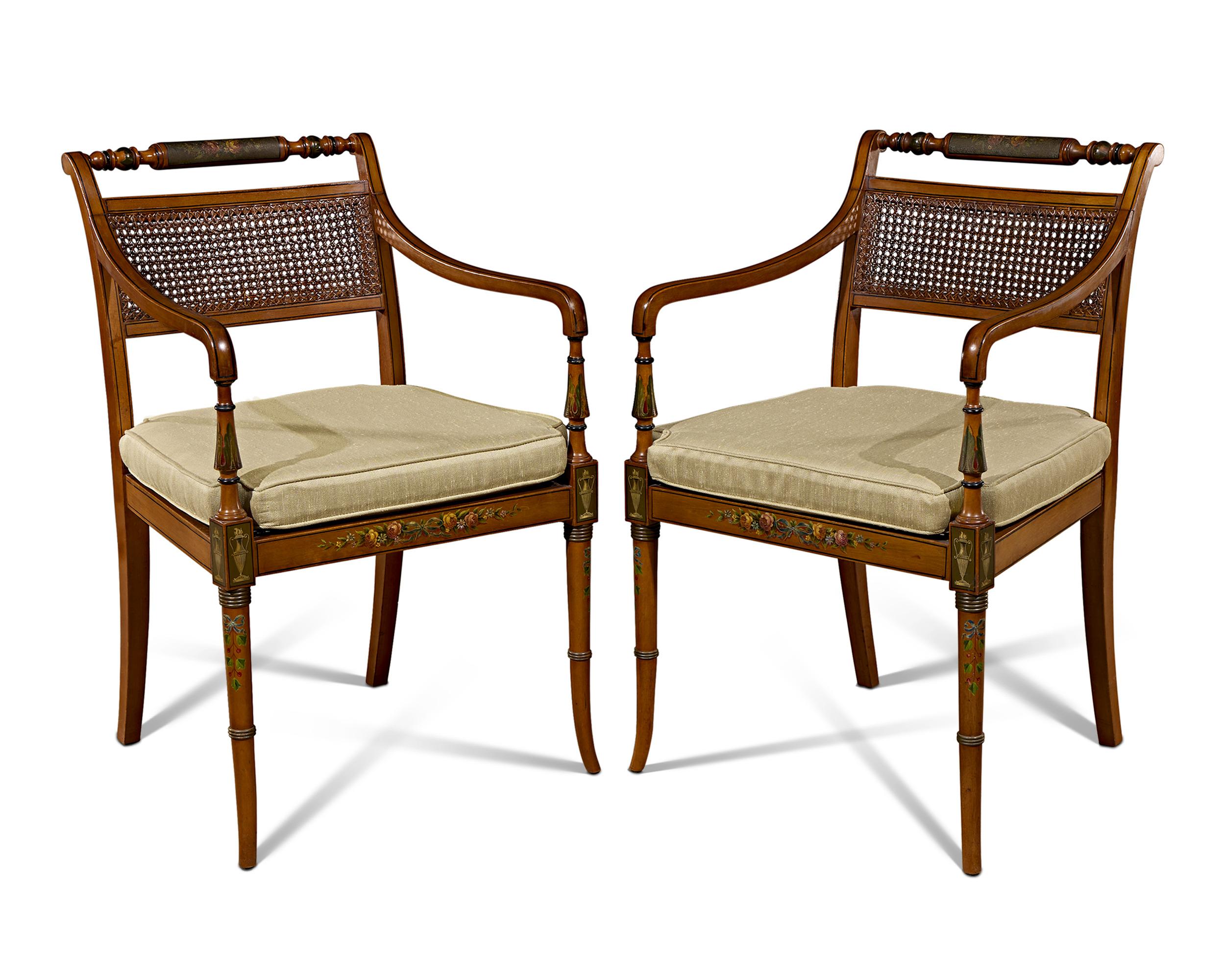 This handsome pair of English satinwood cane chairs is the epitome of the Edwardian style. The lightness of the satinwood and delicate caned back lends an airiness to the design that gained favor during this time, in opposition to the heavier,