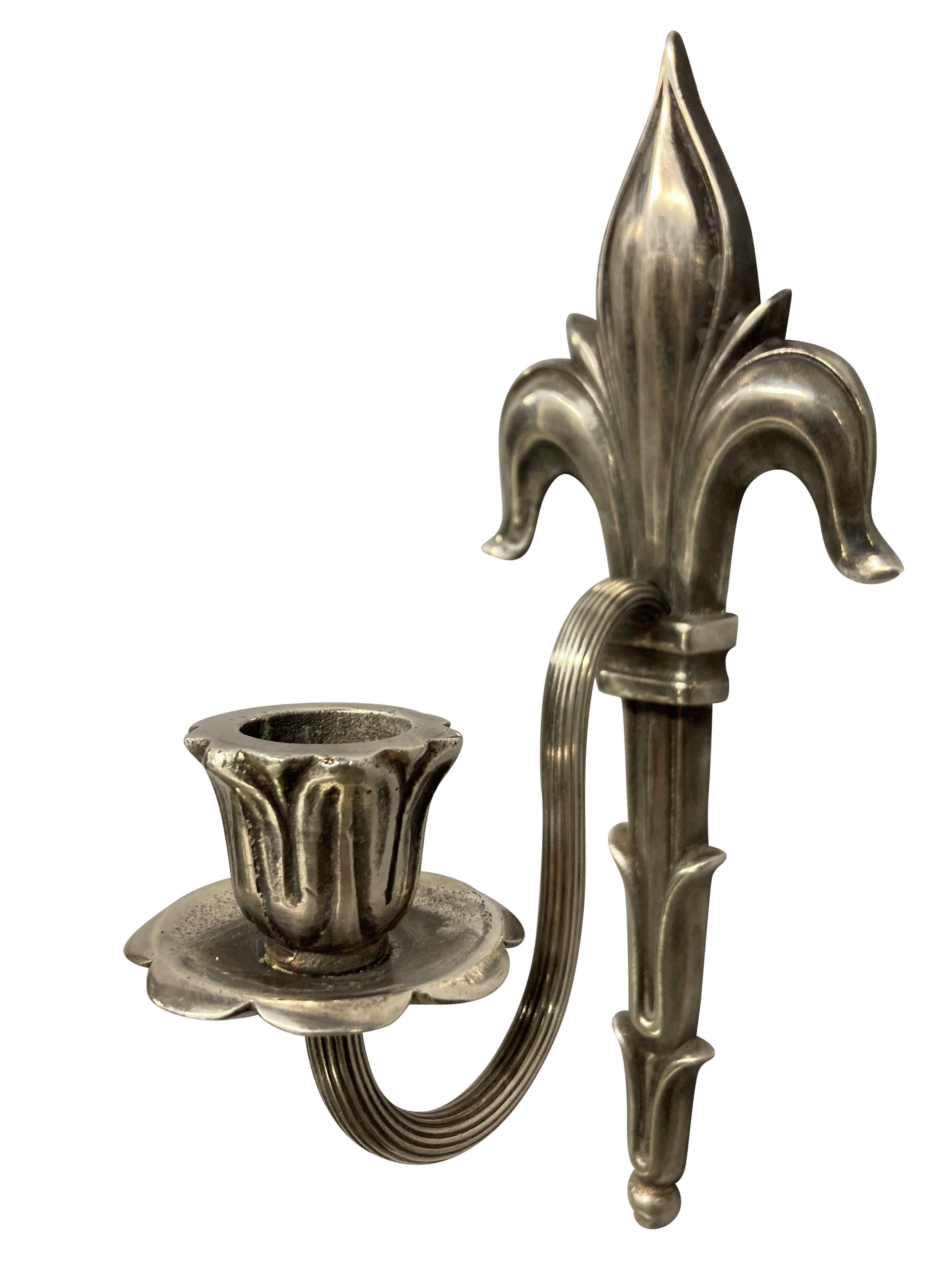 A pair of English Edwardian silver plated single arm sconces with a fleur de lys crest. These have formerly been electrified, but currently are for wax candles.