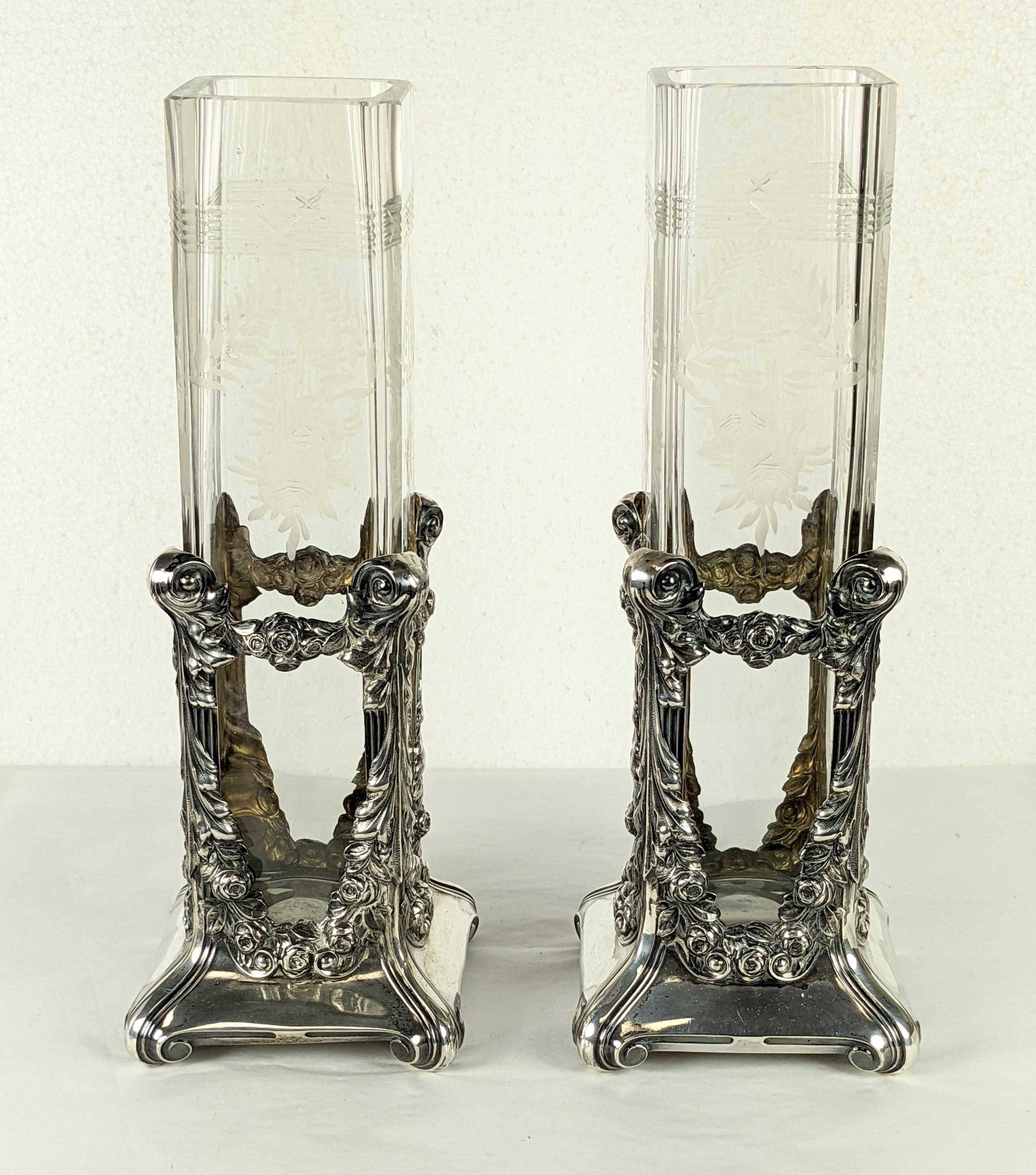 Pair of late lovely 19th century sterling vases with glass liners. Beautifully repousse work with floral swags and scrolls. Liner has etched glass detailing of leaf garlands with roses as well to match the motifs on the silver.
Liners measure 2.5