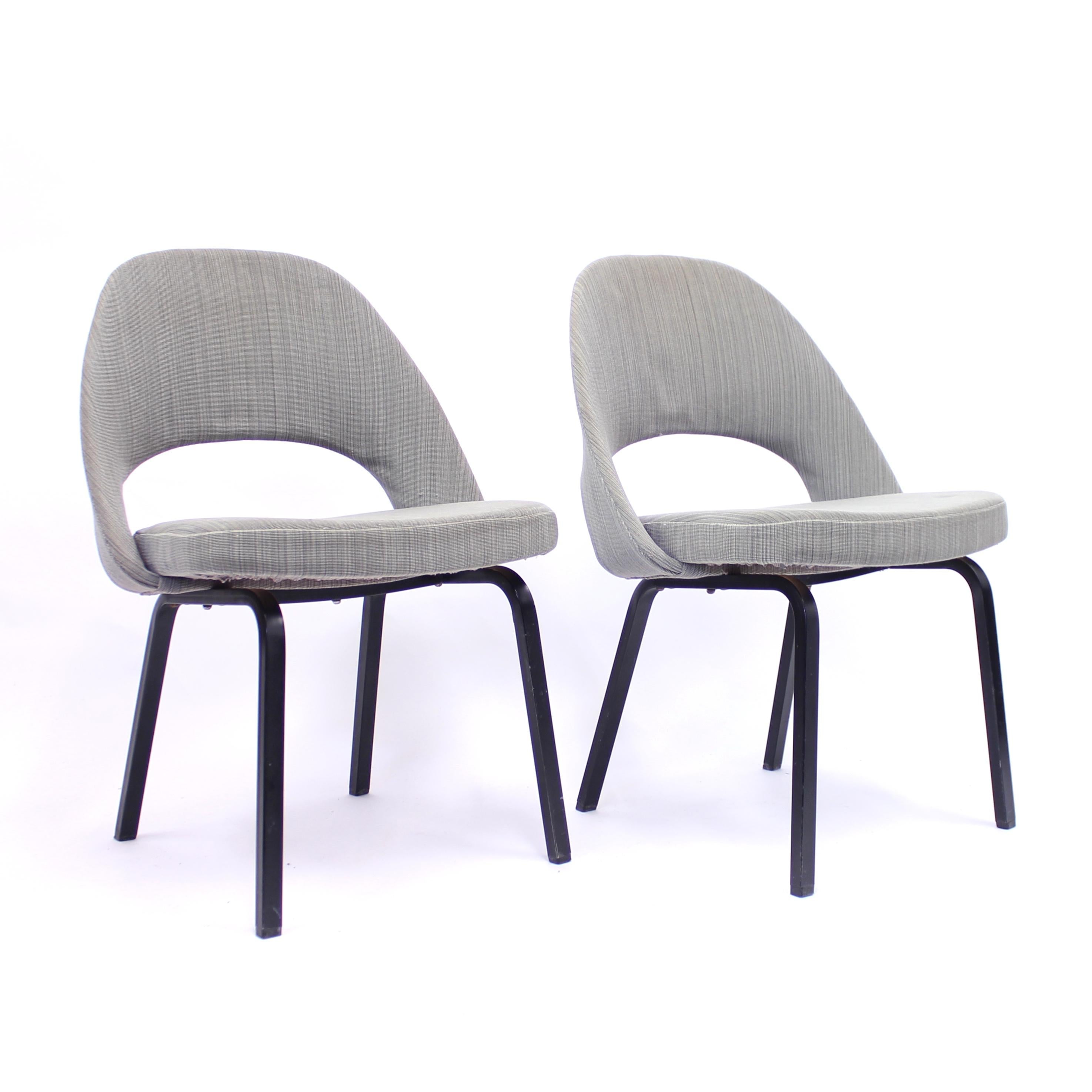 Pair of Eero Saarinen executive chairs by Nordiska Kompaniet under license from Knoll International Ltd. These examples were produced in 1962. They still have their original grey/black/green striped fabric on the back and seat. Black lacquered metal