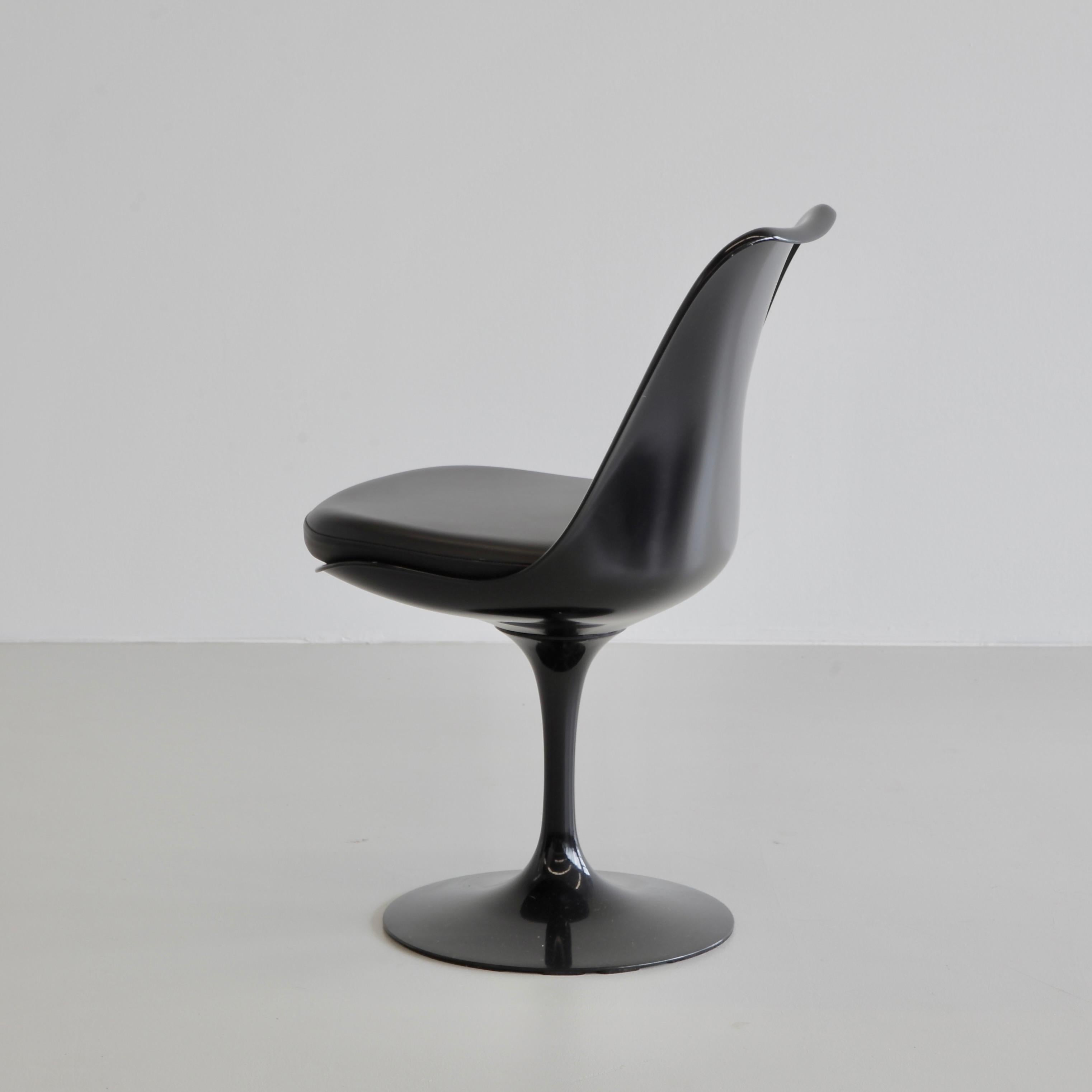 Pair of Tulip chairs designed by Eero Saarinen. U.S.A., Knoll International.

Black cast aluminium tulip bases with swivel seats. Original early 21st century chairs with 'Knoll Studio' metal logo underside of the base. Black leatherette seat