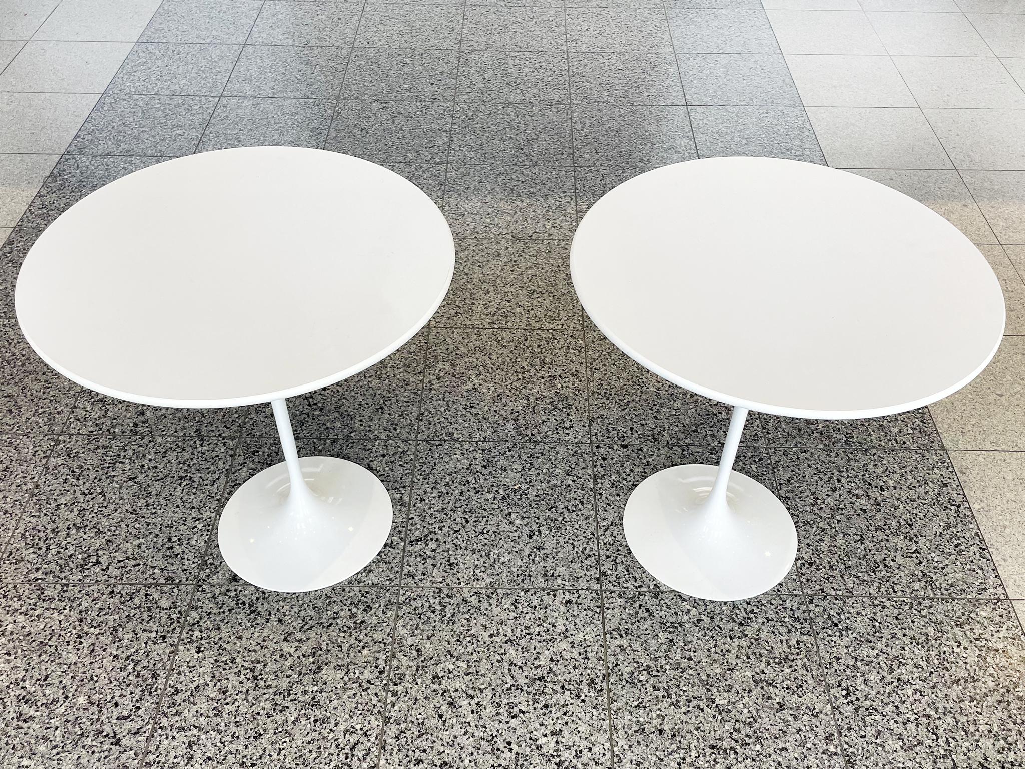 Iconic tulip tables designed by Eero Saarinen for Knoll in the 1950s. This pair was manufactured in the late 20th century. White laminate, beveled tops and white pedestal bases.

Dimensions:
20 in. diameter
20 in. height

Condition notes:
In