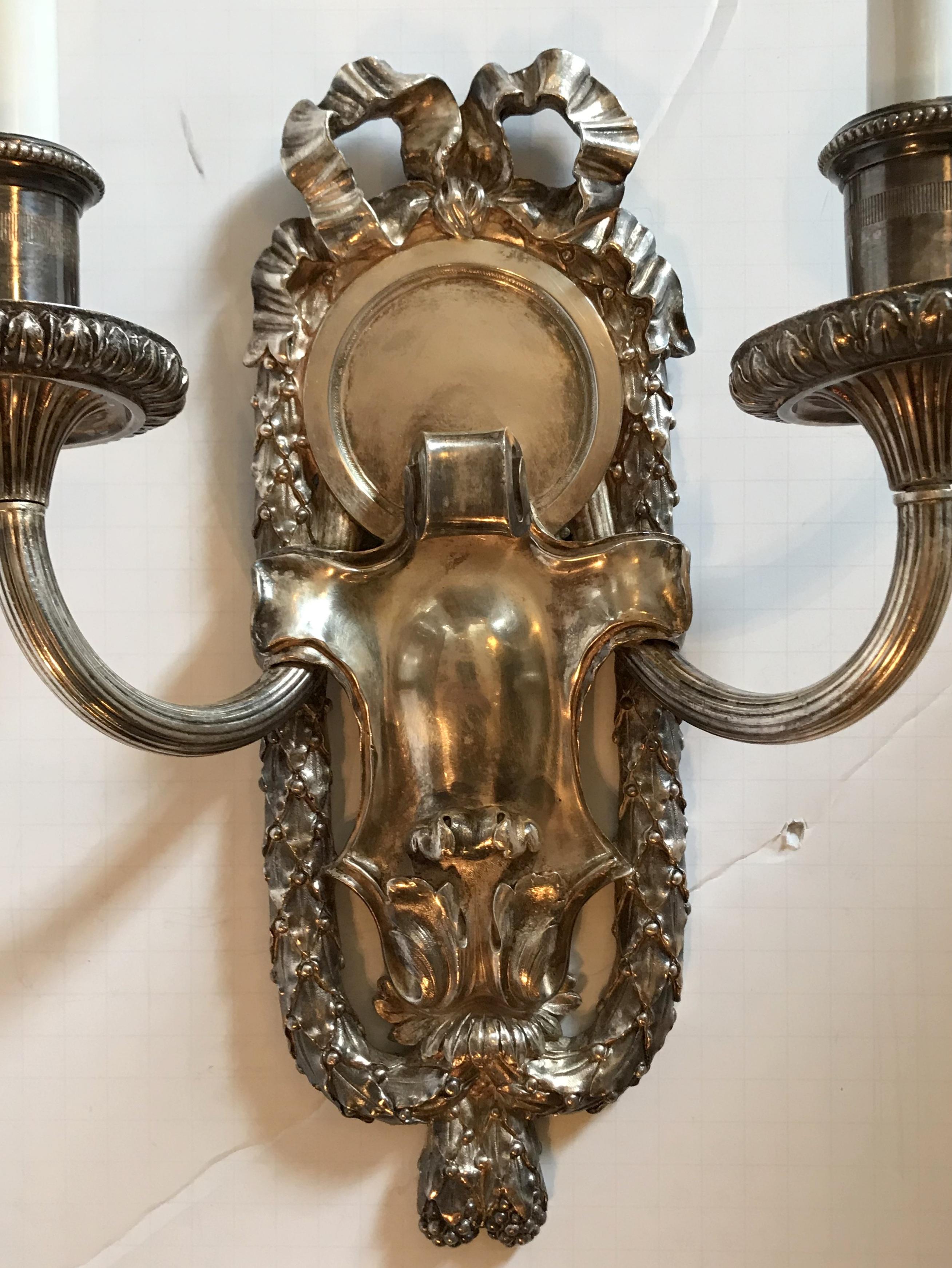 Silvered Pair of E.F. Caldwell Polished Silver Two-Arm Neoclassical Bow-Top Sconces For Sale