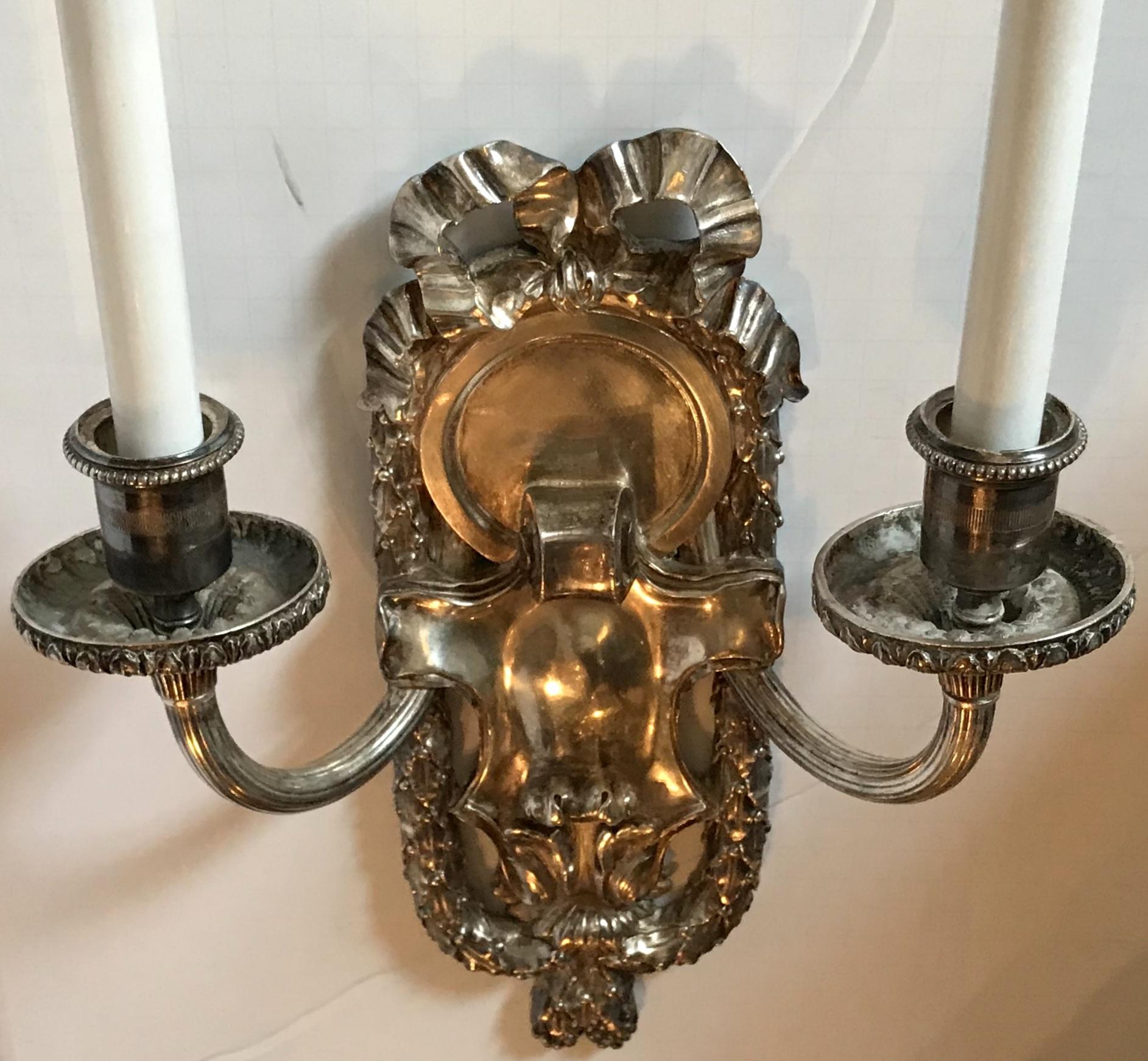 20th Century Pair of E.F. Caldwell Polished Silver Two-Arm Neoclassical Bow-Top Sconces For Sale