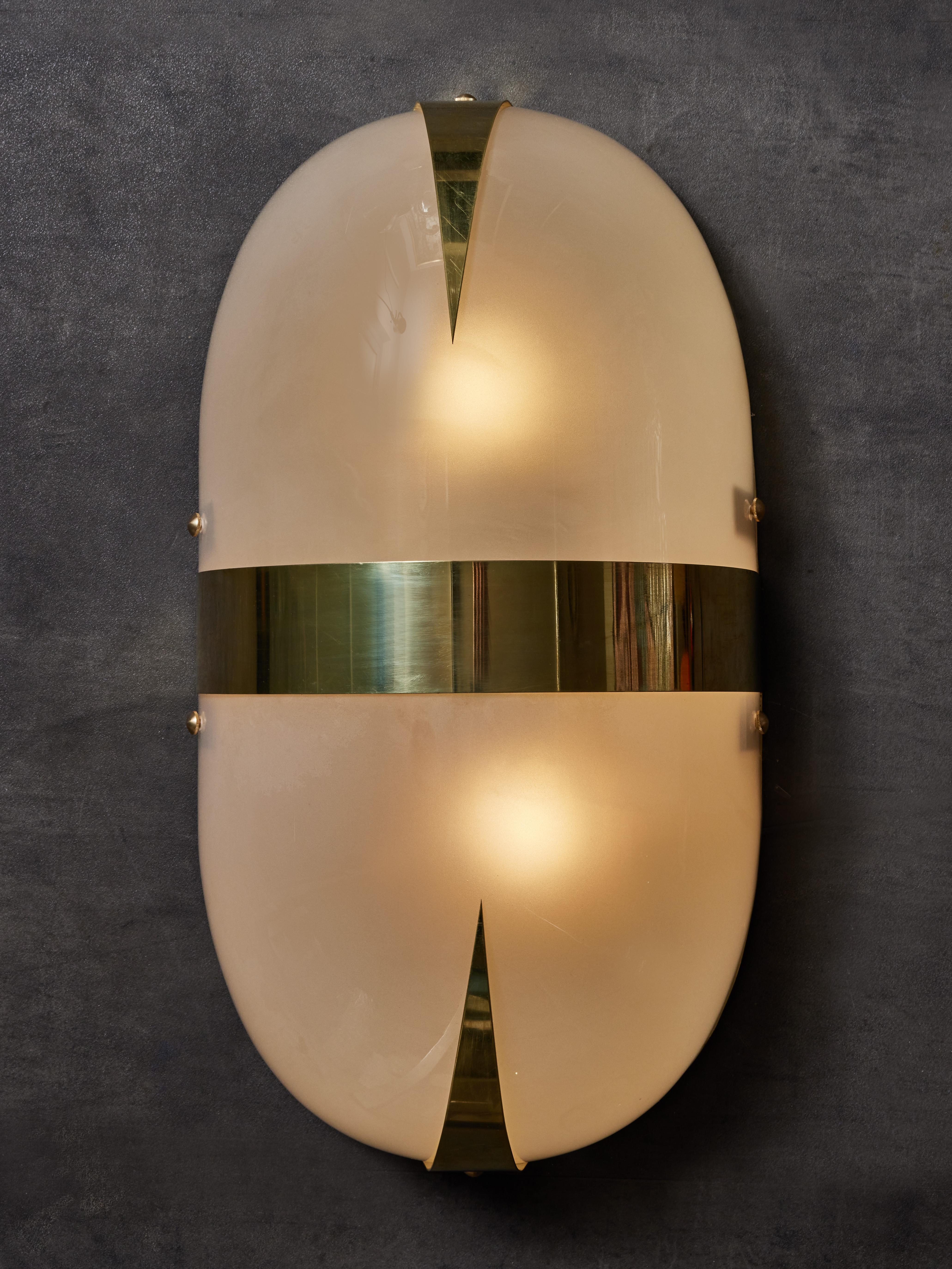 Pair of wall ovoid shaped wall sconces made of two tinted Murano glass shells with brass decors.