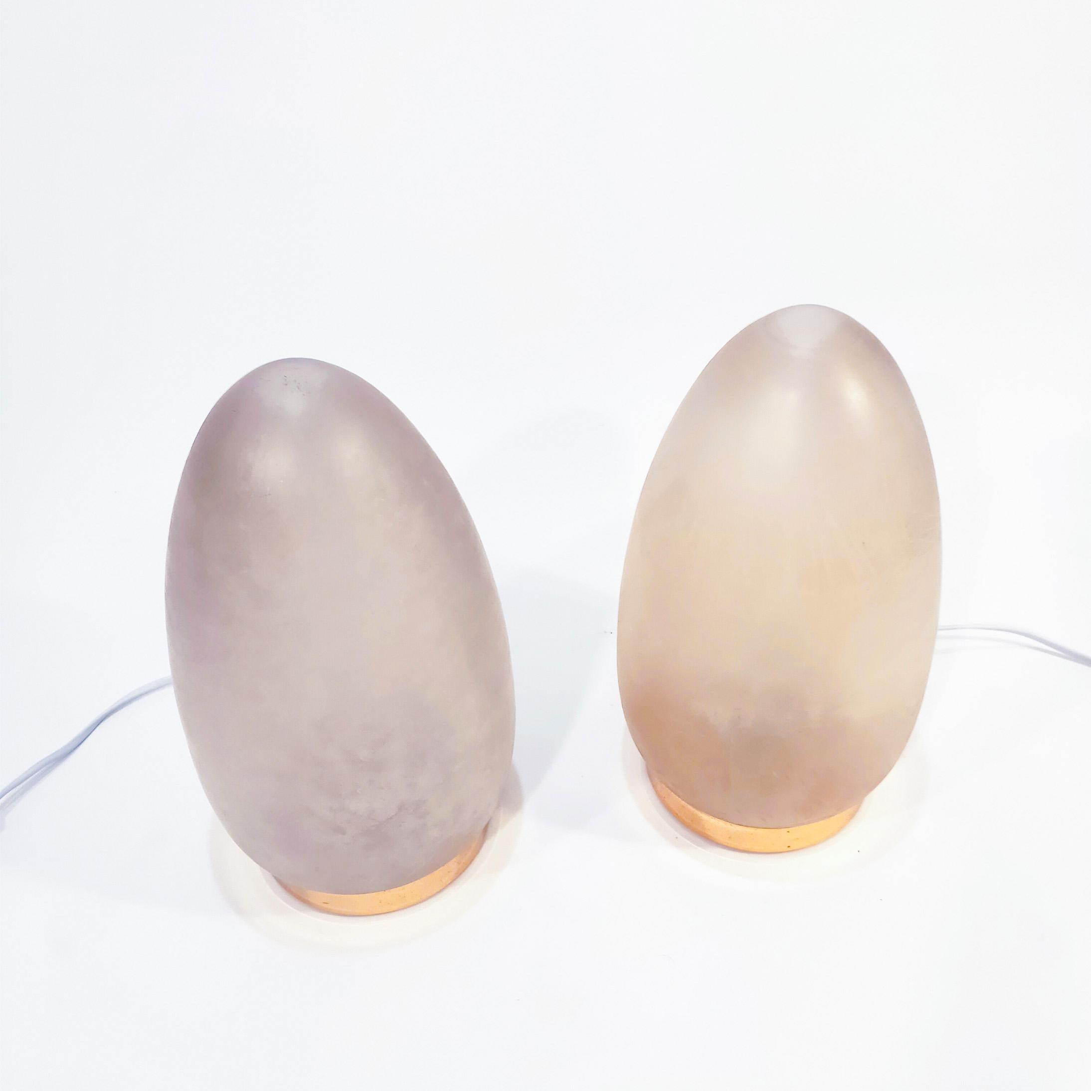 Pair of Italian table lamps from the 70s. Frosted egg-shaped glass body in a grayish-pink tone, with a golden chromed metal base. Its shape evokes the typical ovoid lamps of the Italian Murano brands Mazzega, F. Fabbian and Fontana Arte.
For one E27