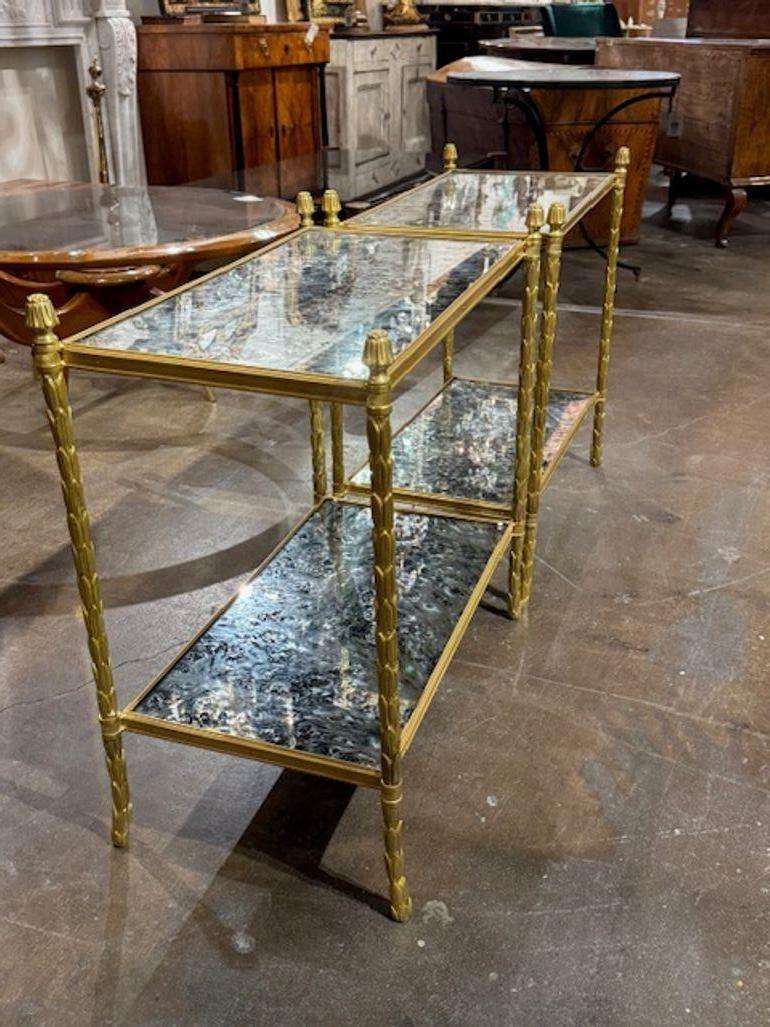 Superbe paire de tables d'appoint en bronze doré et verre églomisé à la manière de Jansen. Cette table d'appoint en bronze doré et verre églomisé à la manière de la Maison Jansen est une luxueuse pièce d'accent néoclassique, parfaite pour ajouter du