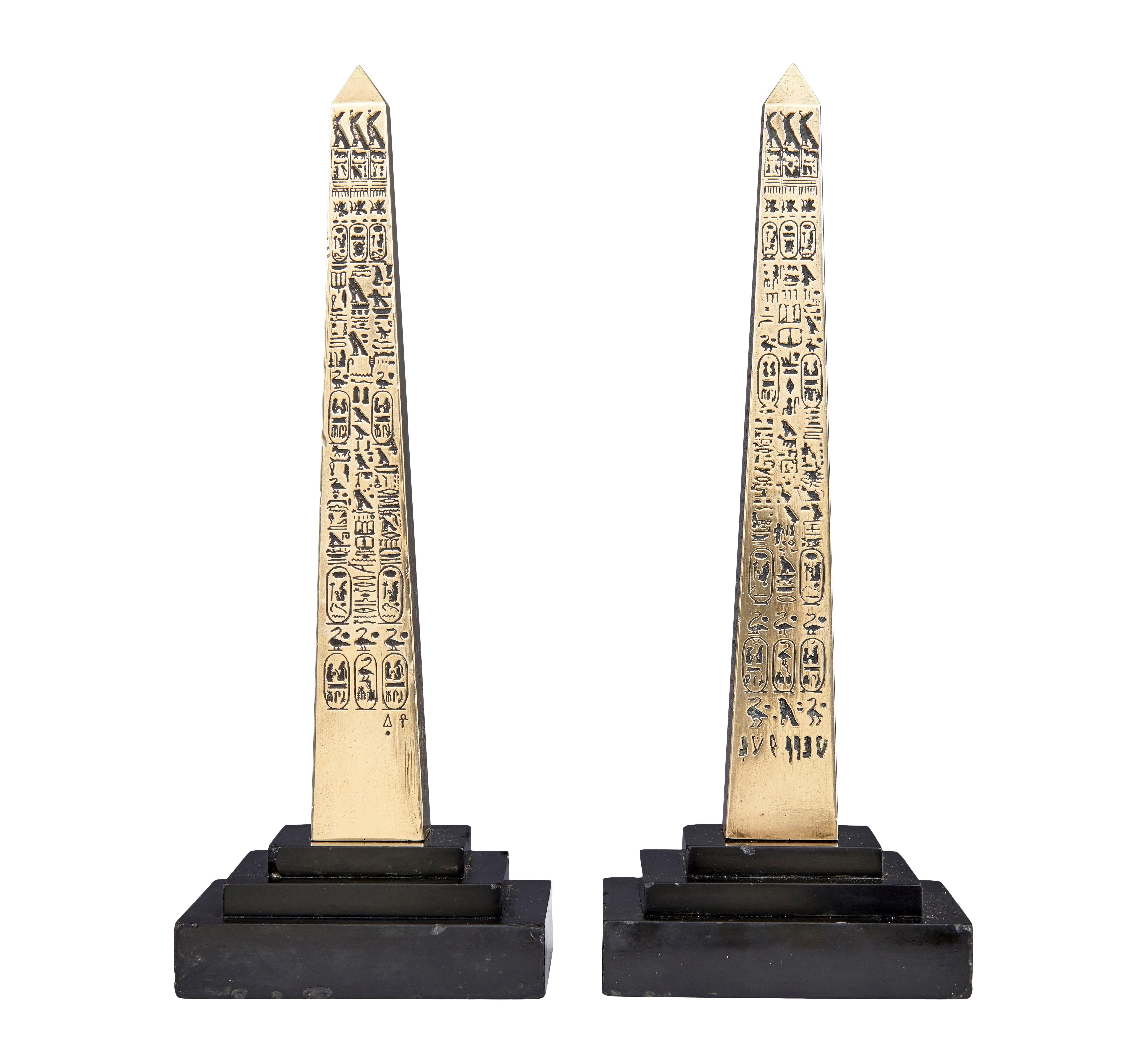 Pair of Egyptian revival desktop brass obelisks circa 1920.

Here we have a pair of art deco period decorative items.  Polished brass obelisks decorated each side with egyptian hieroglyphics.  Each standing on black marble stepped
