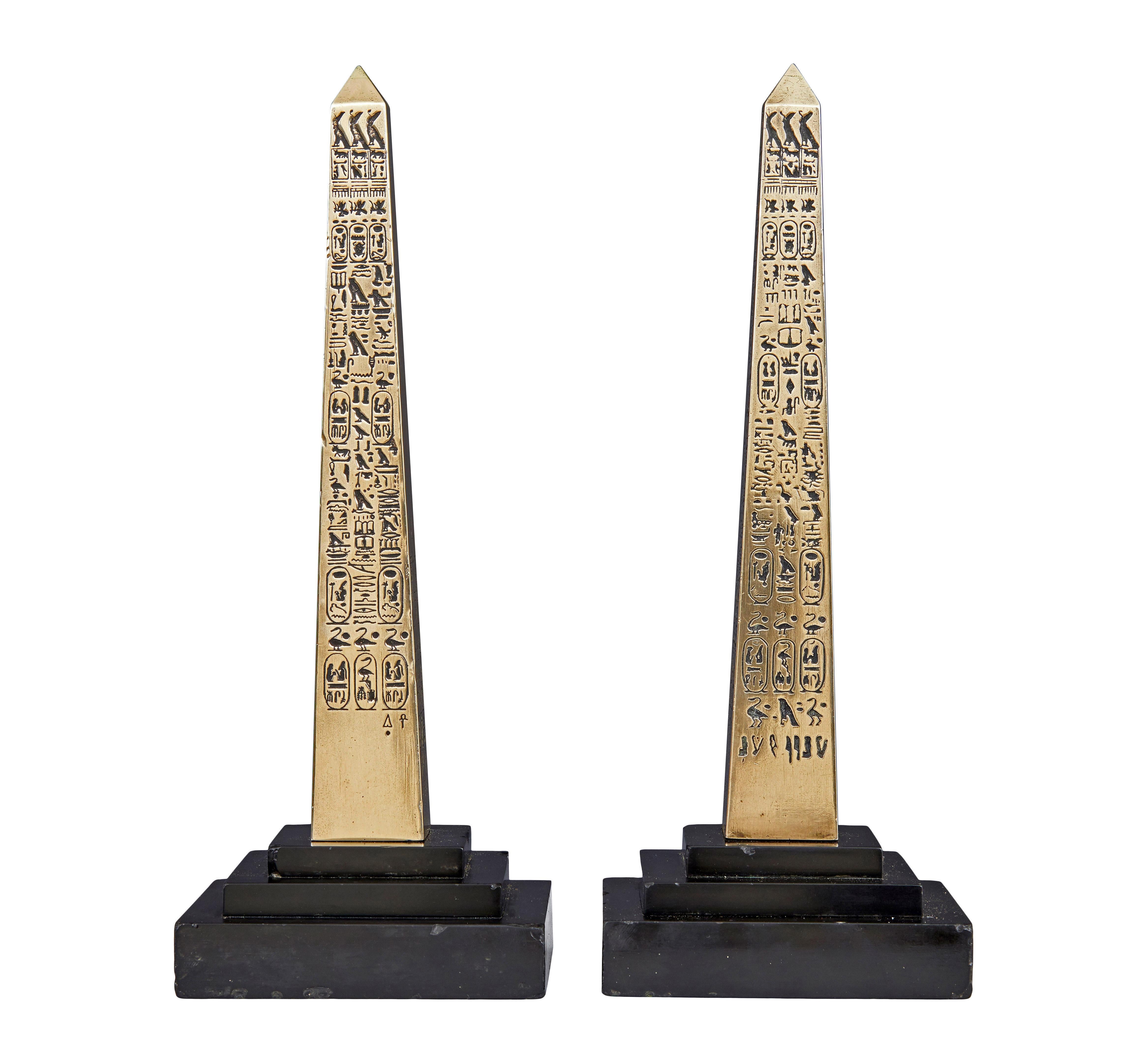 Ein Paar ägyptische Obelisken aus Messing um 1920.

Hier haben wir ein Paar Dekorationsartikel aus der Zeit des Art déco.  Polierte Obelisken aus Messing sind auf jeder Seite mit ägyptischen Hieroglyphen verziert.  Sie stehen jeweils auf gestuften