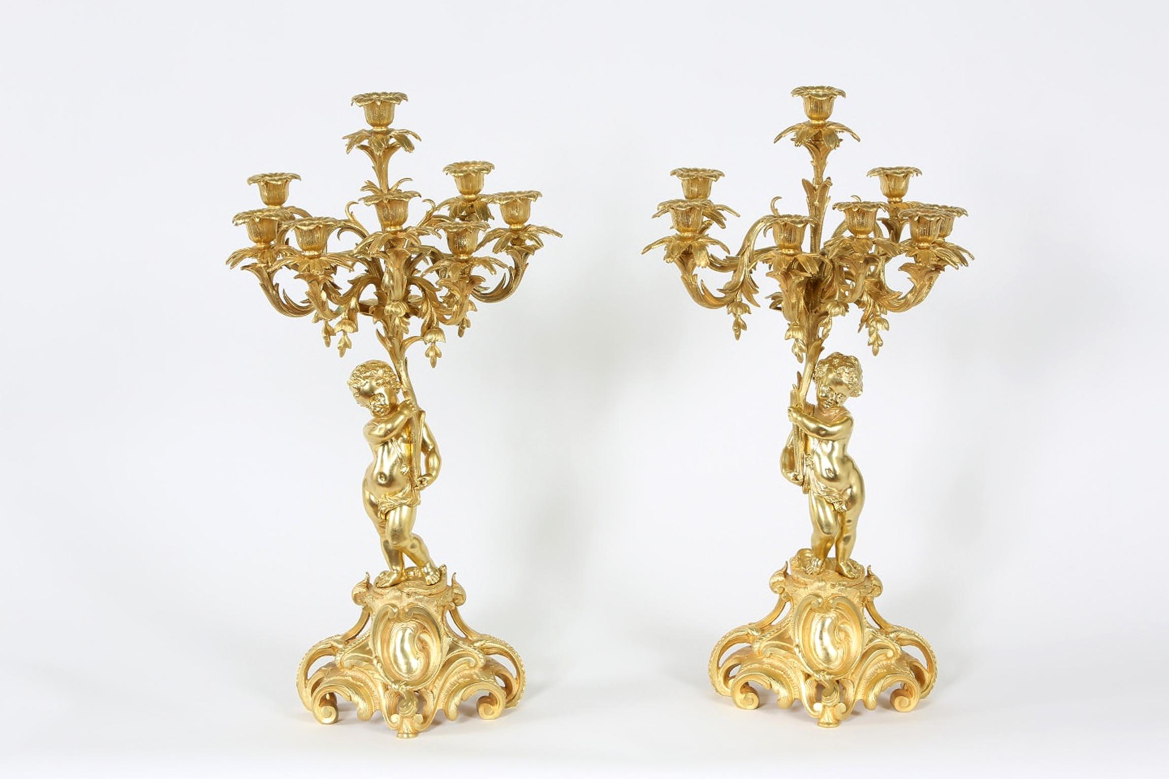 Pair of eight armed gilt bronze centerpiece candelabras with standing Putti atop scroll form base & exterior design details. Each candelabra is in great condition. Each one measure about 25 inches high x 9 inches diameter. Minor wear appropriate