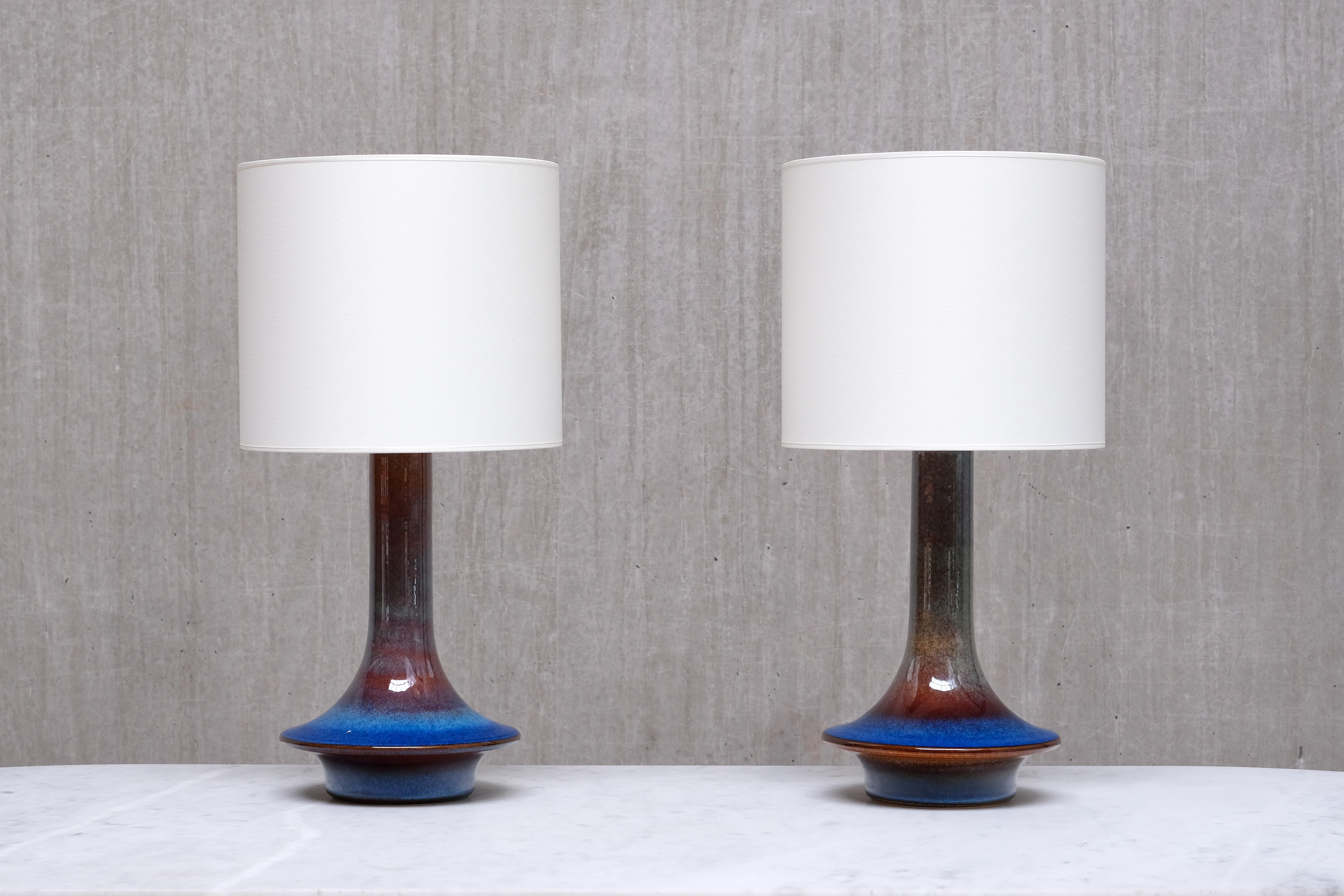 This striking pair of table lamps was designed by Einar Johansen and produced by Søholm Stentøj in Denmark during the 1960s.
Each lamp is stamped with the manufacturer’s name and the model number 1068 on the underside of the base.

The stoneware