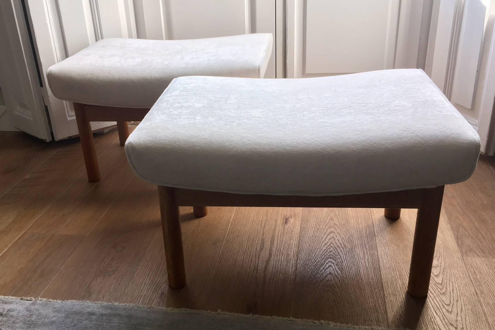 Ein Paar Hocker von Ejner Larsen und Aksel Bender, hergestellt von Willy Beck, Kopenhagen, Dänemark 1961. Gestell aus Eichenholz, gepolstert mit weißem Veloursstoff. Die Sitze sind auf der Unterseite mit den Namen des Herstellers und der Architekten