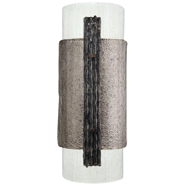 The Elba sconce has been inspired by the Brutalist era of the 20th century. A modern take on the wall sconce, this piece uses three types of handcrafted Murano glass, with silver leaf and patinated brass detailing and fixings. 

Takes E27 bulbs.