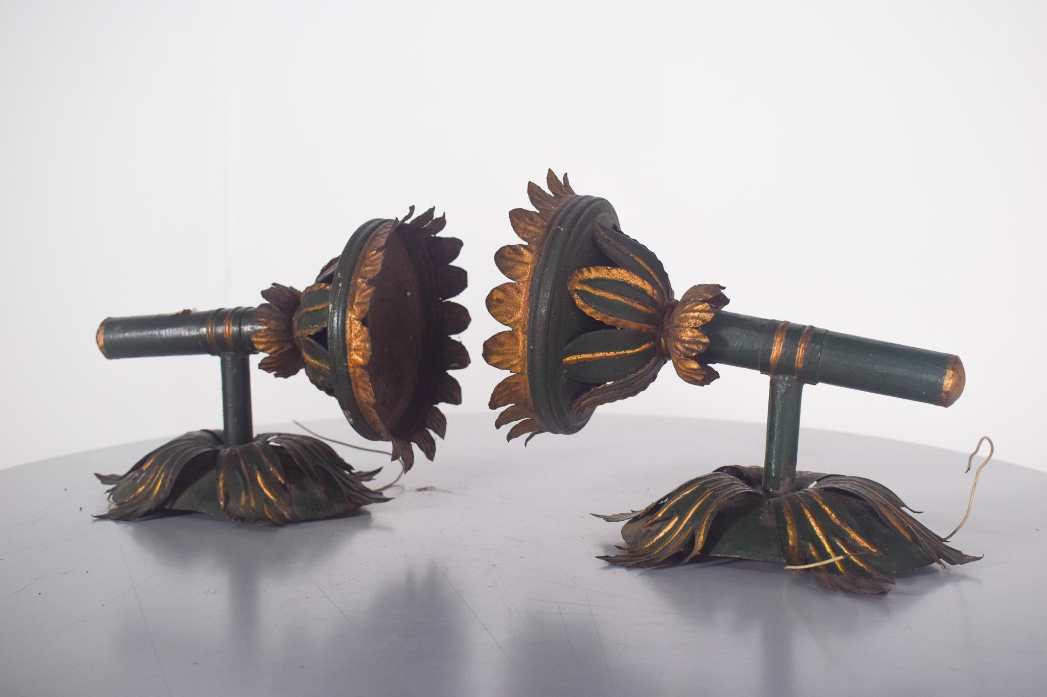 Paire d'appliques électrifiées en forme de torche. En métal forgé, tons vieillis de vert foncé et d'or. La forme rappelle les feuilles et les pétales, soigneusement façonnés pour créer un aspect exquis et ornemental.
Le support est doté d'une base
