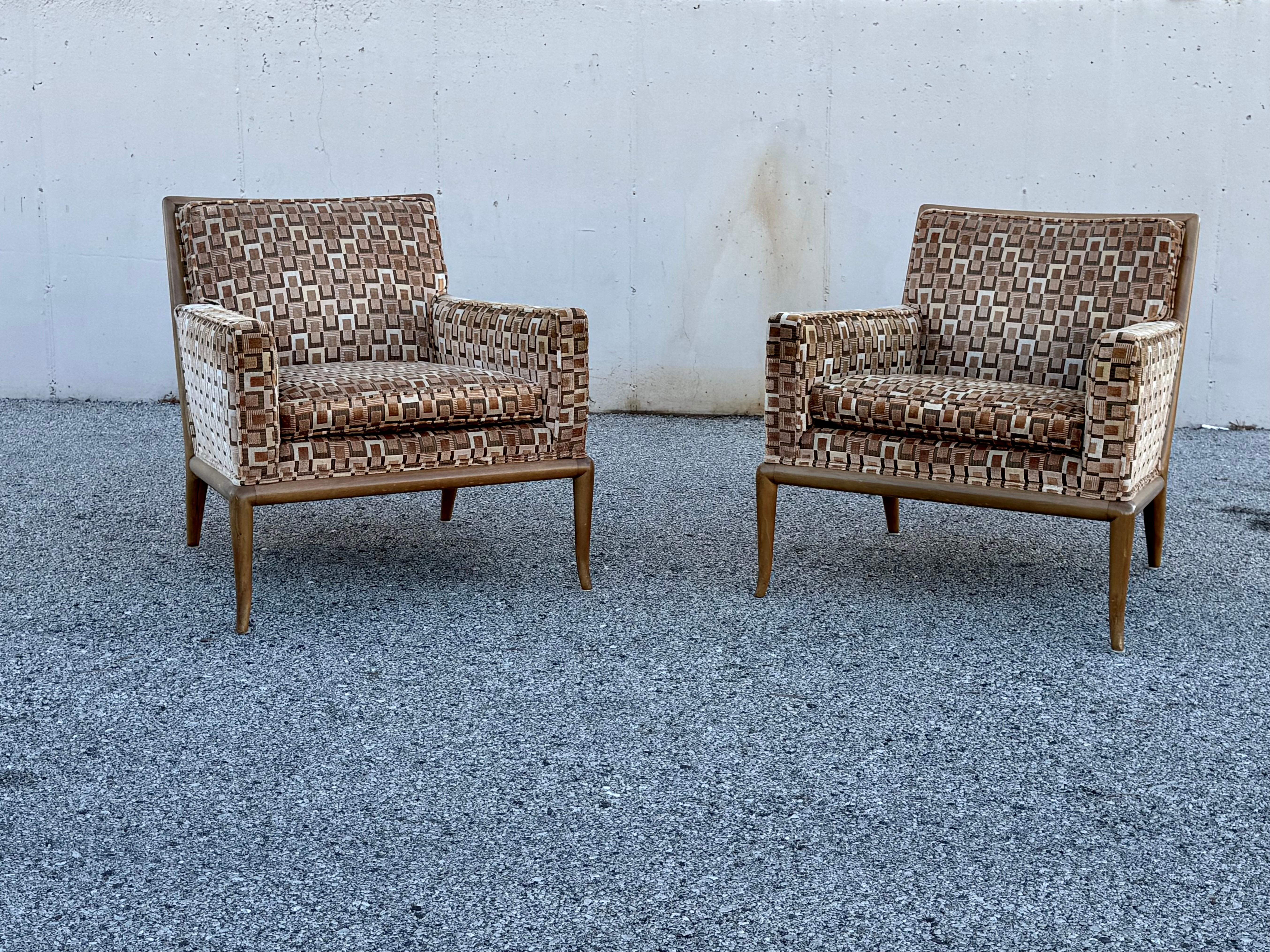Elegant pair of 1950s lounge chairs by T.H. Robsjohn-Gibbings for Widdicomb with sculpted walnut frame on splayed legs. Shown in original finish that is sun faded, price includes refinishing, custom colors available. Older replacement upholstery is