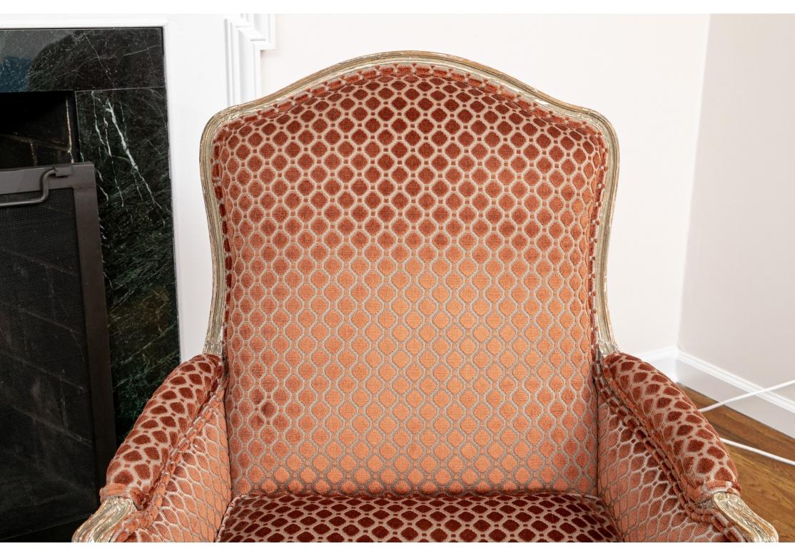 Liegestühle im Stil von Louis XV. In antikem, weiß lackiertem Distressed-Finish. Mit schräger Rückenlehne, geschwungenen Armlehnen und schlangenförmigen Sockelleisten, die auf Cabriole-Beinen ruhen. Gepolstert mit einem rostfarbenen, kreisförmig