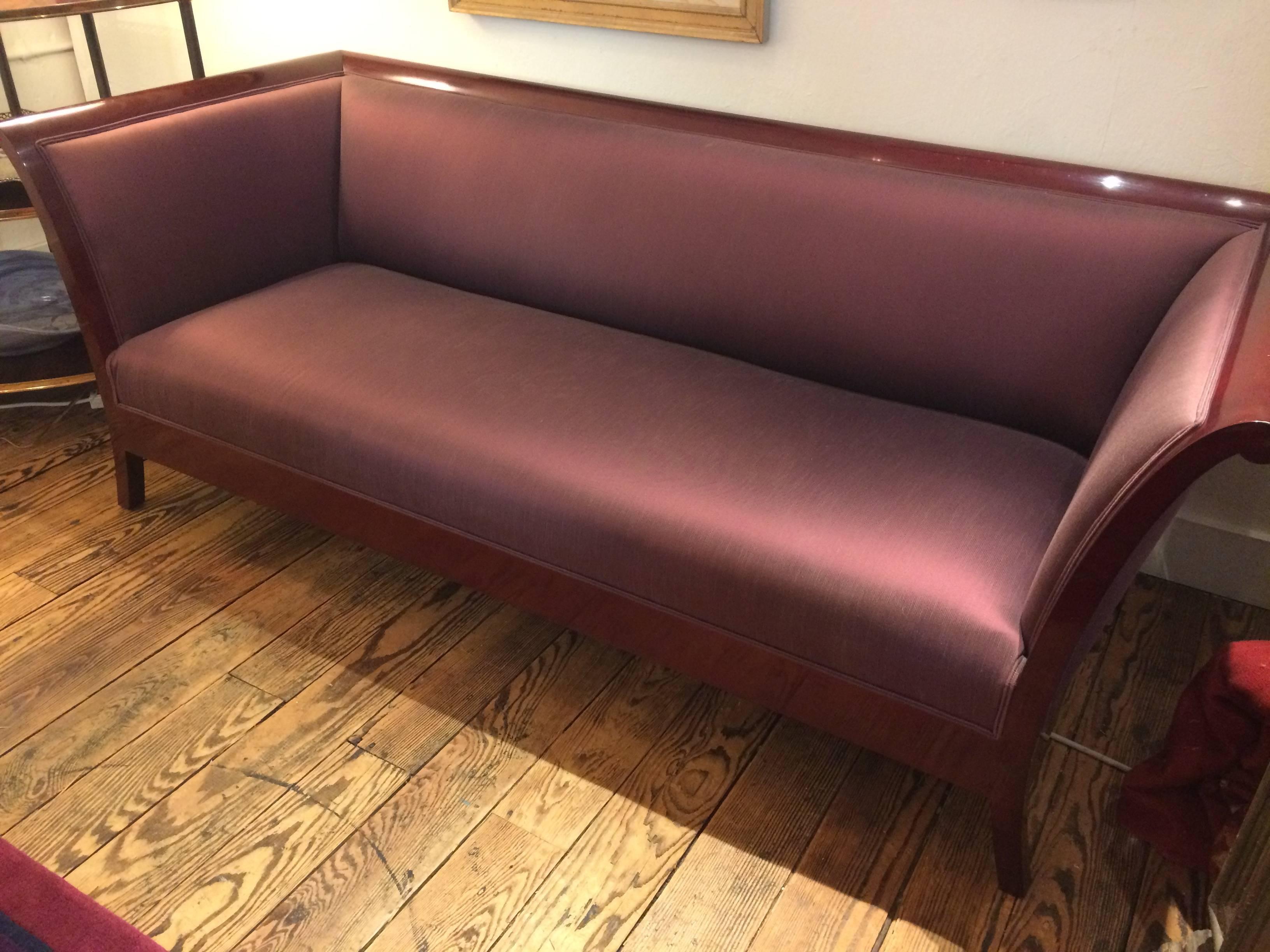 A pair of gorgeous sleek deco inspired sofas by Kenneth Winslow having high gloss cherry frames, upholstered in a purple mauve fabric that changes color depending on amount of direct sunlight. Firm very comfortable seating.
Measure: seat height 16,