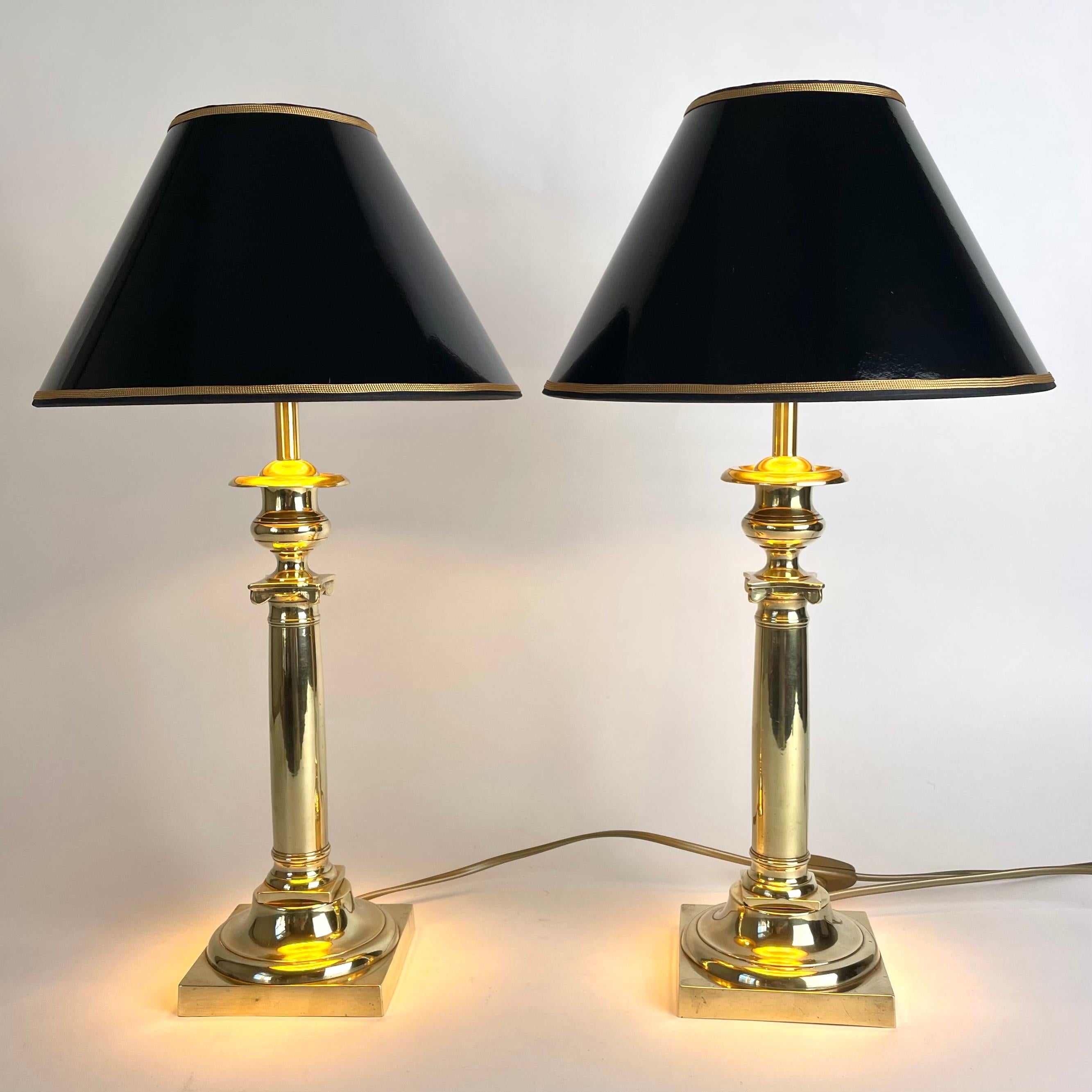 Pair of Elegant Empire Table Lamps in bronze, early 19th Century France, originally candlesticks.

Includes new black lacquer lampshade with gold details, giving the lamp a warm and golden glow. Newly rewired electricity.

Wear consistent with age