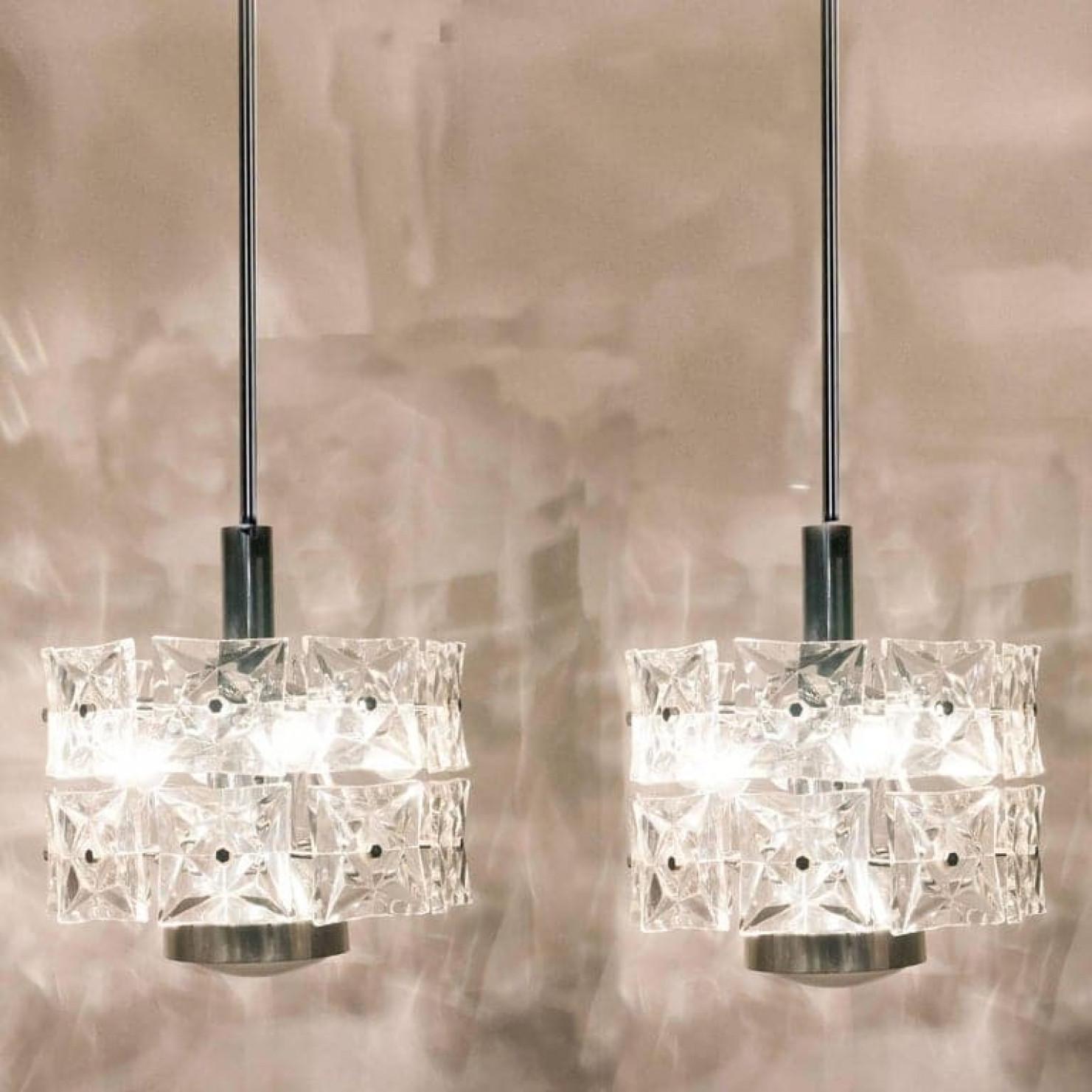 A pair of very modern, elegant and fine Kinkeldey chandeliers. Really heavy quality. They are comfortable with all decor periods. This chandeliers are executed to a very high standard. The quality large square crystals beautifully reflecting the