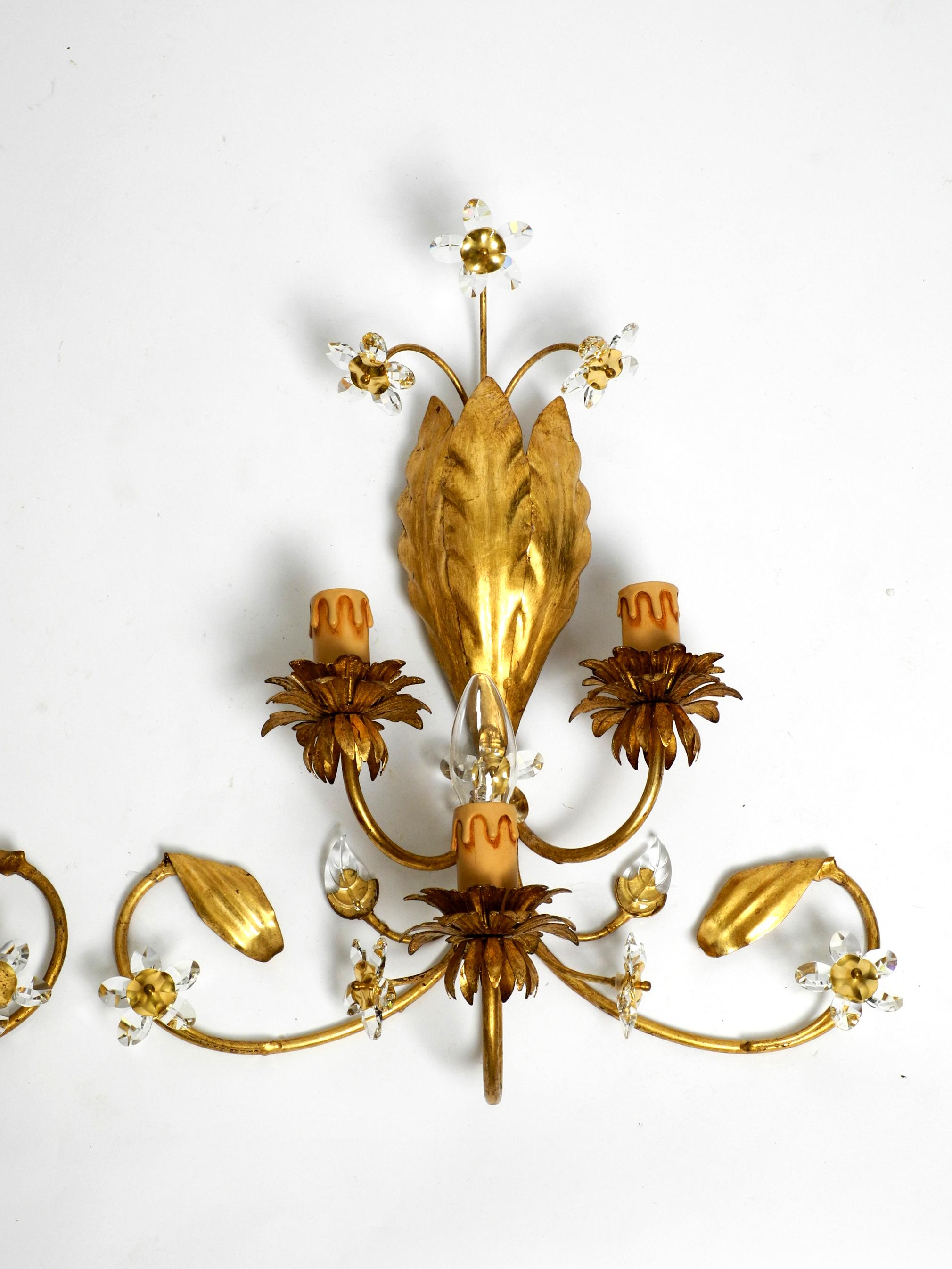 Pair of elegant Italian 1980s floral Hollywood Regency design wall lamps.
Stunning beautiful elaborate design with many details. Made in Italy.
The iron frame is completely gilded. With small glass stones, assembled in the shape of flowers. Very