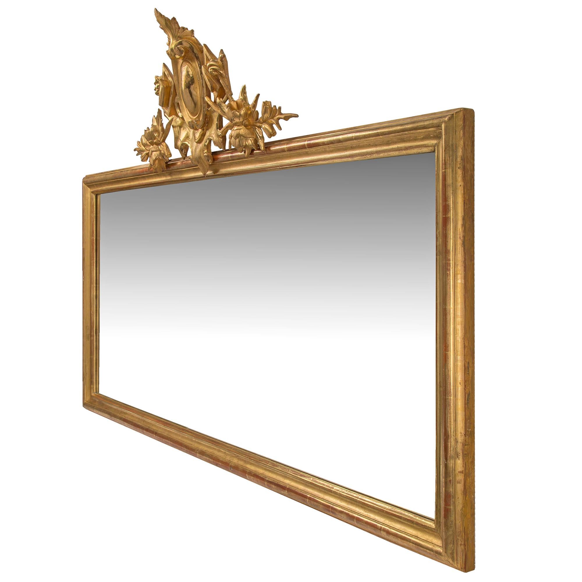 Une paire d'élégants miroirs horizontaux italiens en bois doré du XIXe siècle. Chaque miroir, avec sa dorure d'origine, est doté d'un fin cadre moulé qui borde la plaque du miroir d'origine. Le sommet de chaque pièce présente une réserve centrale